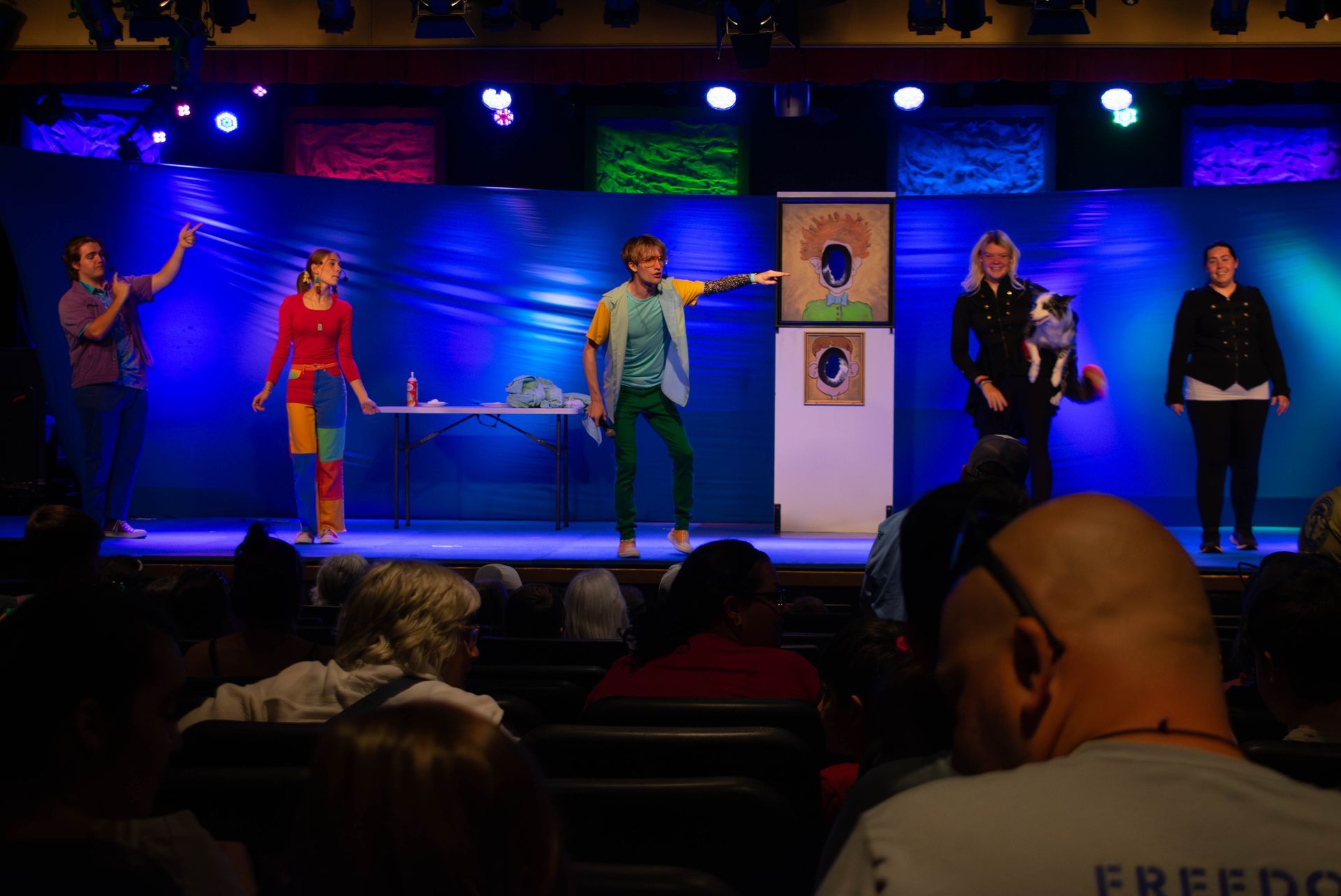 A group of people are standing on a stage in front of a crowd.