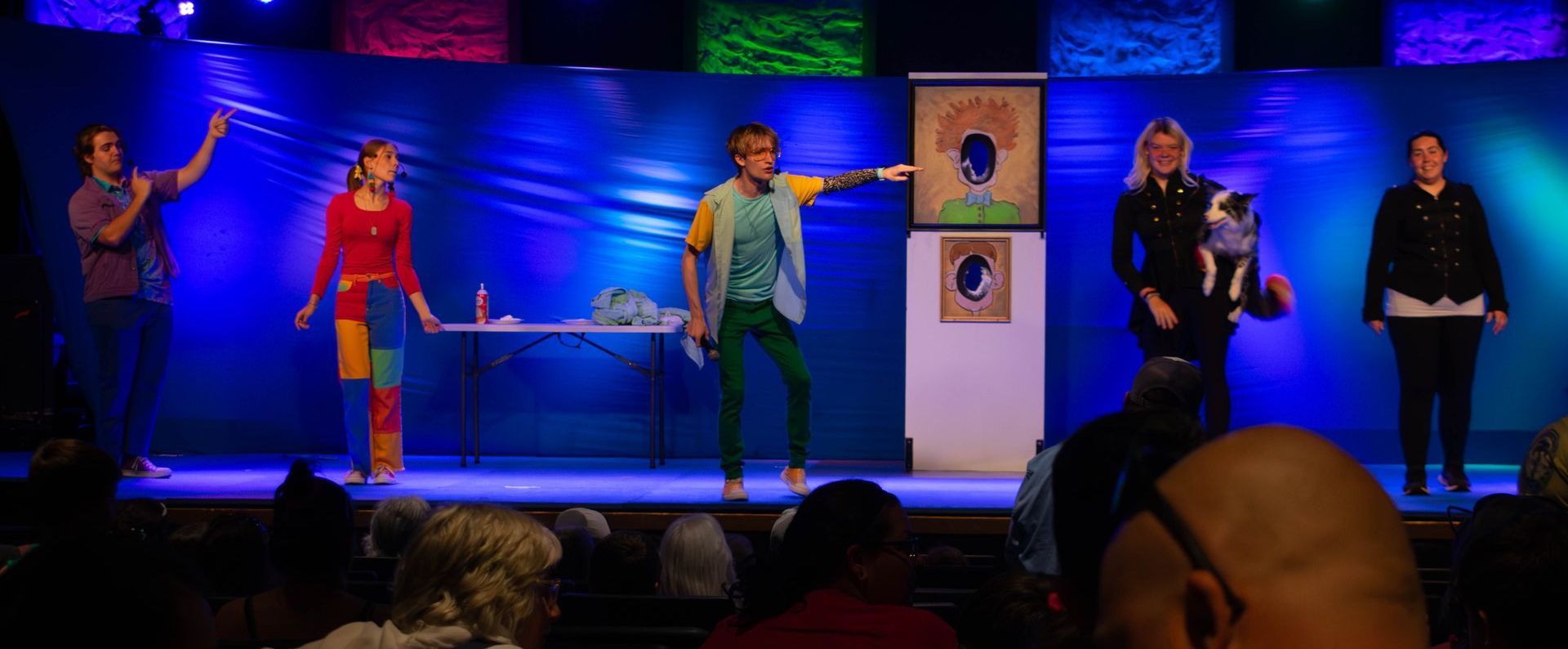 A group of people are standing on a stage in front of a crowd.