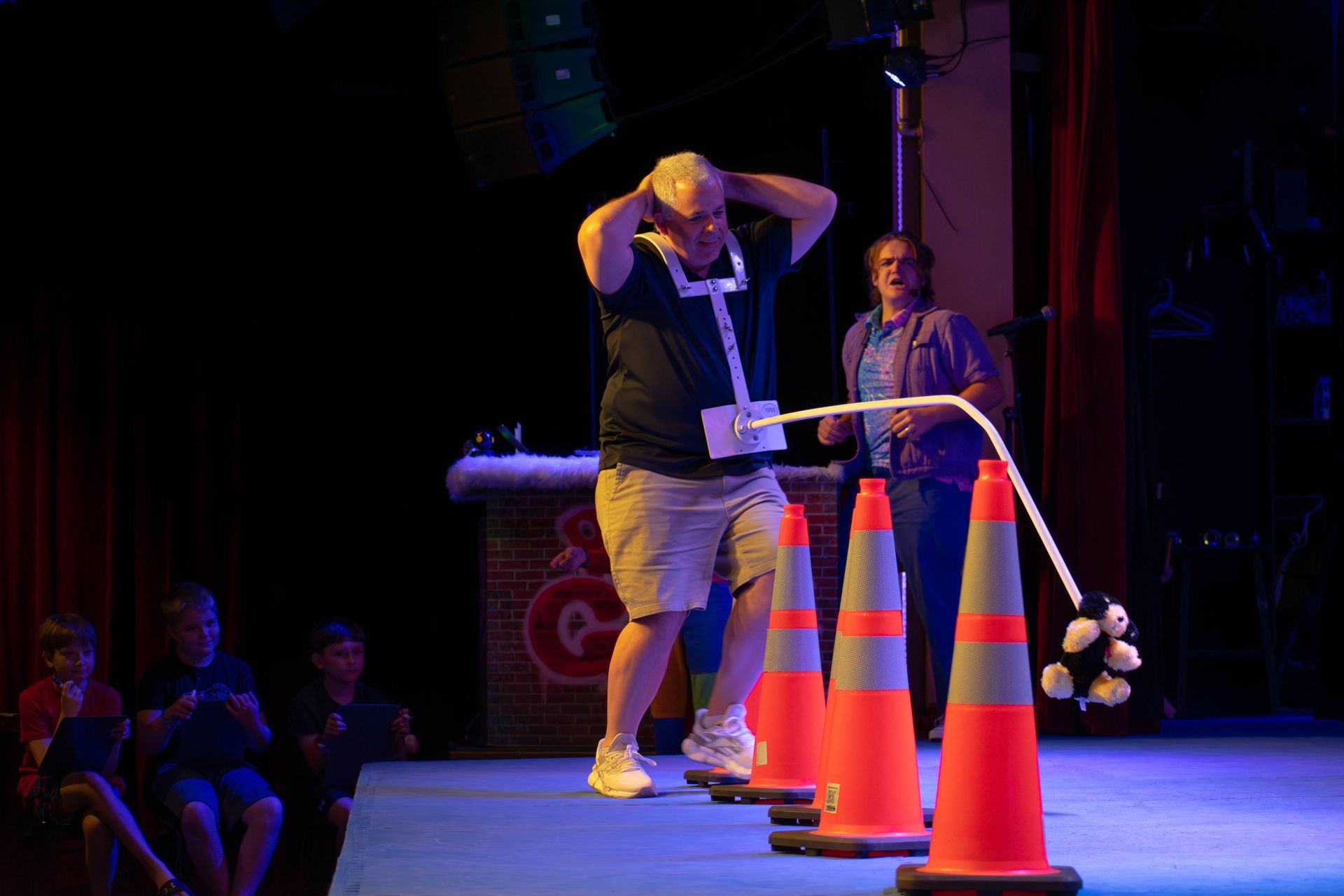A man is standing in a line of traffic cones on a stage.