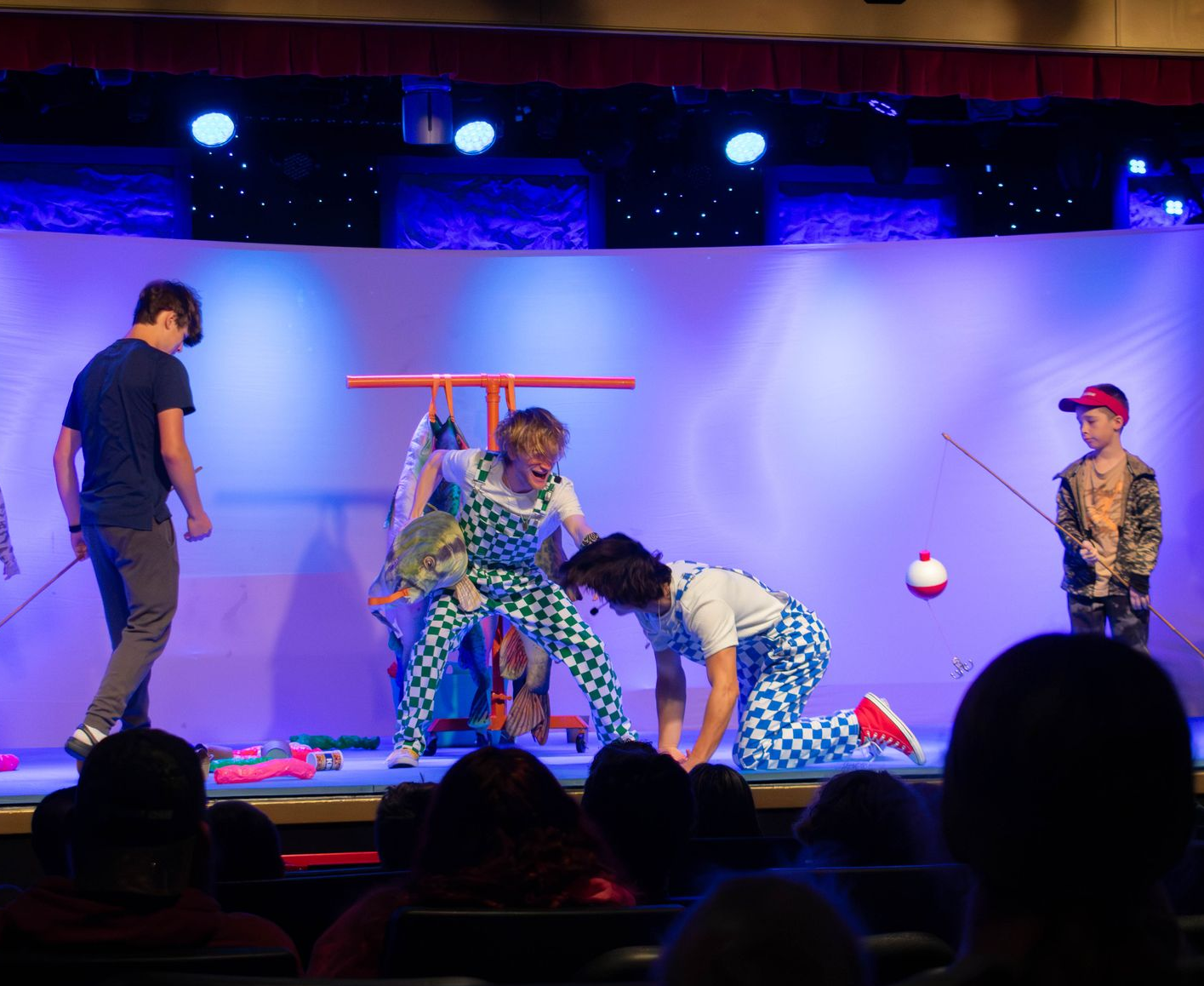 A woman is doing a trick with a dog on her shoulders