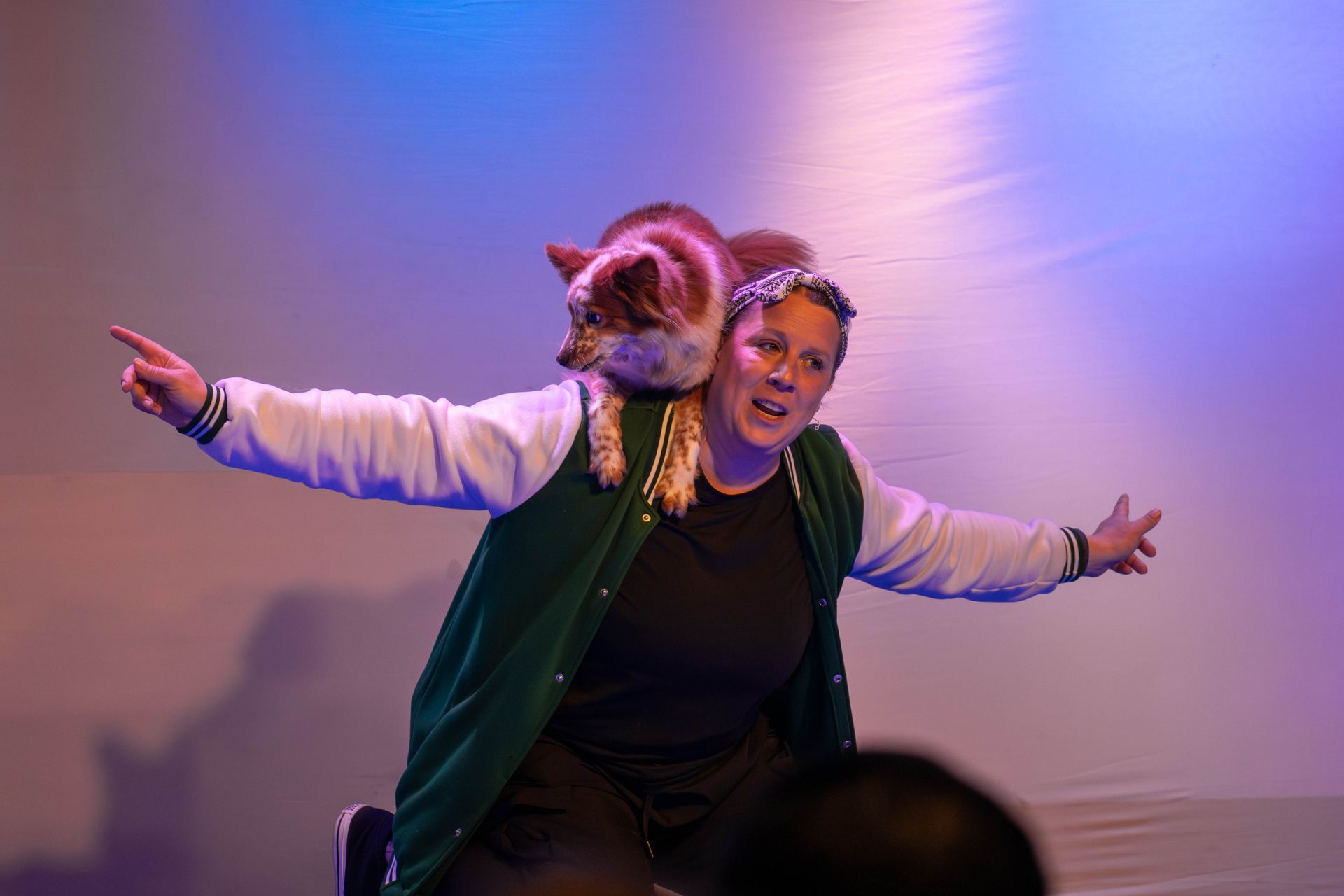 Four men in suits are singing into microphones on a stage.