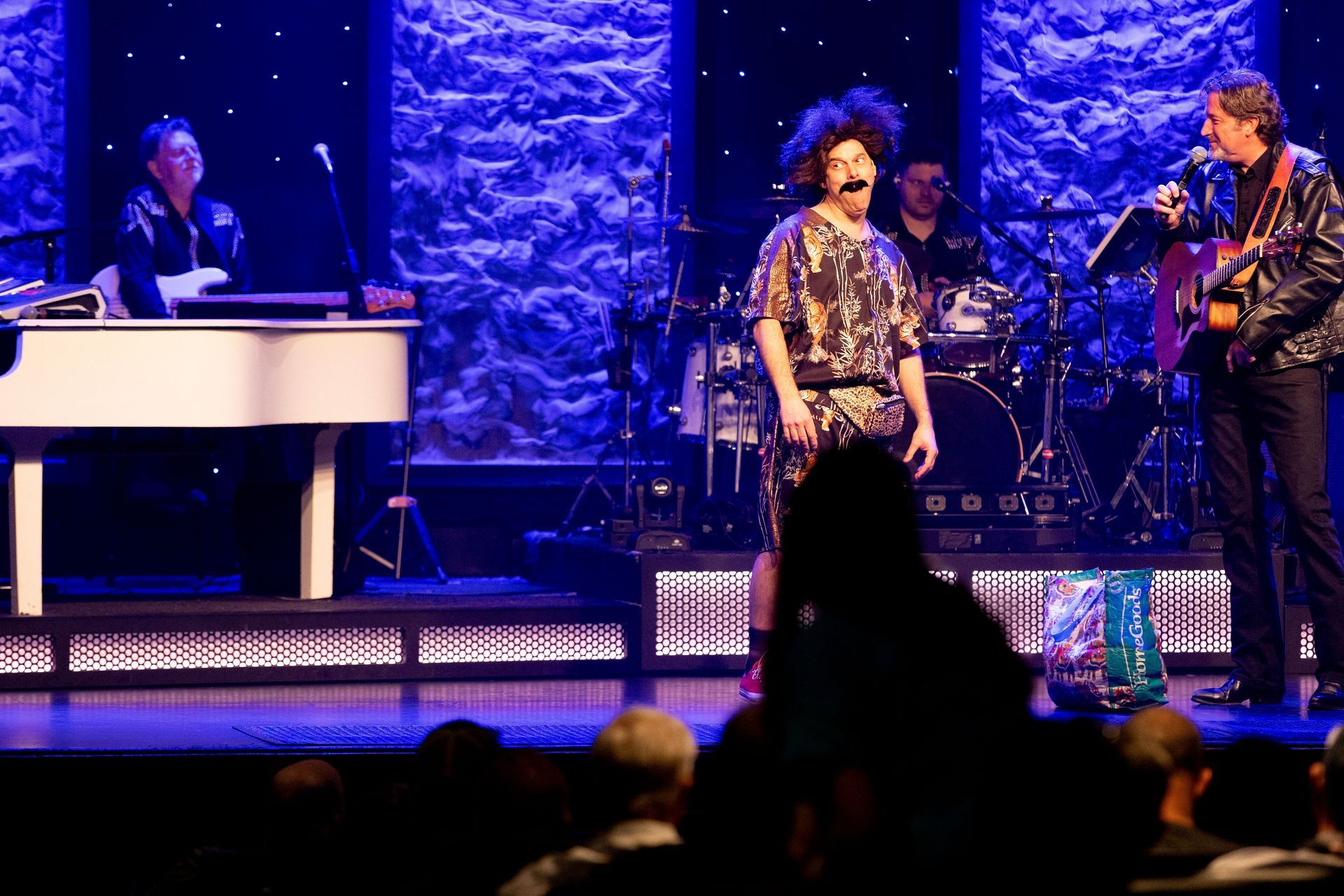A group of people are standing on a stage playing instruments.