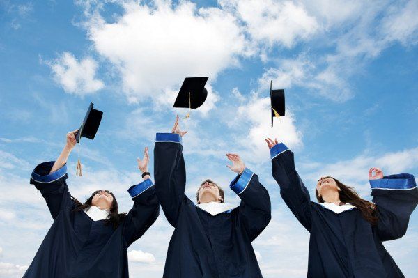 A group of graduates are throwing their caps in the air