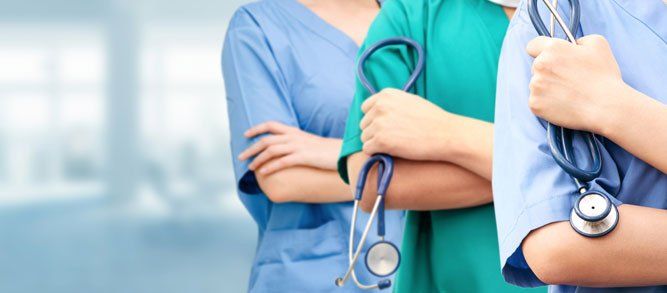 A group of doctors and nurses standing next to each other holding stethoscopes.