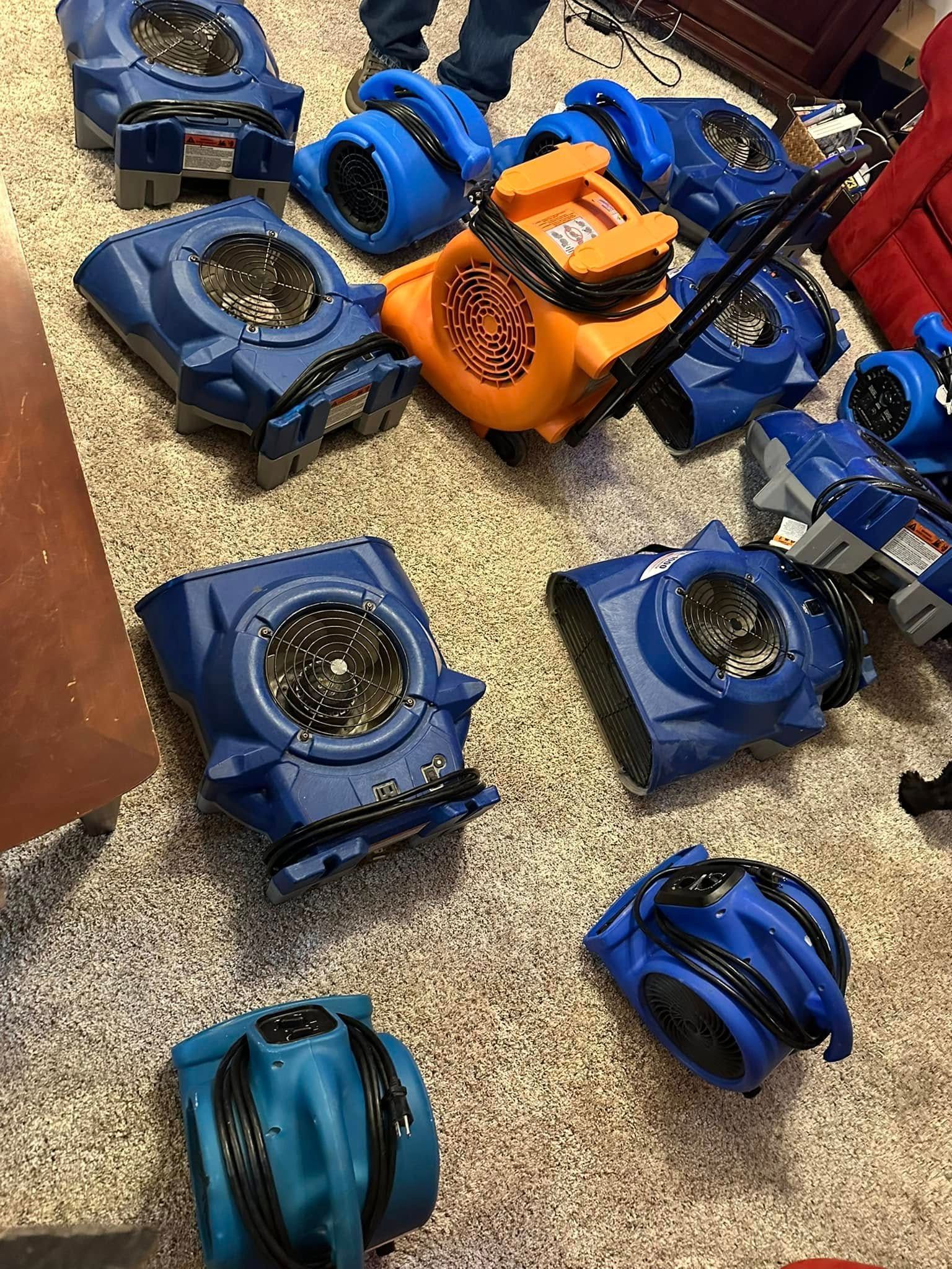 Blue and orange toy vehicles scattered on a carpeted floor.