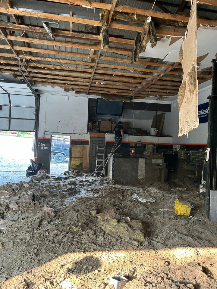 Interior of a building under demolition, debris on the ground, damaged ceiling.