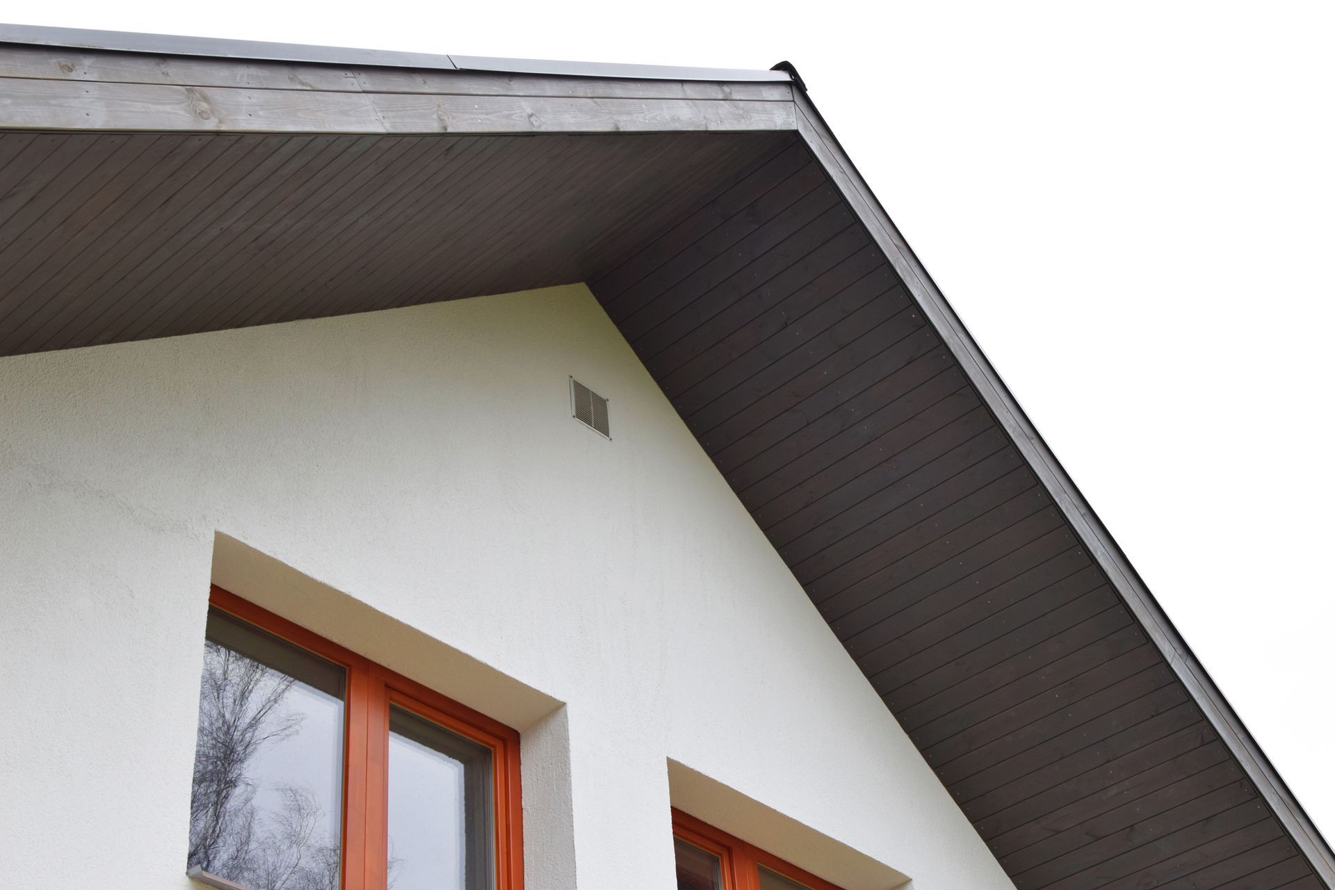 A white house with a brown roof and two windows