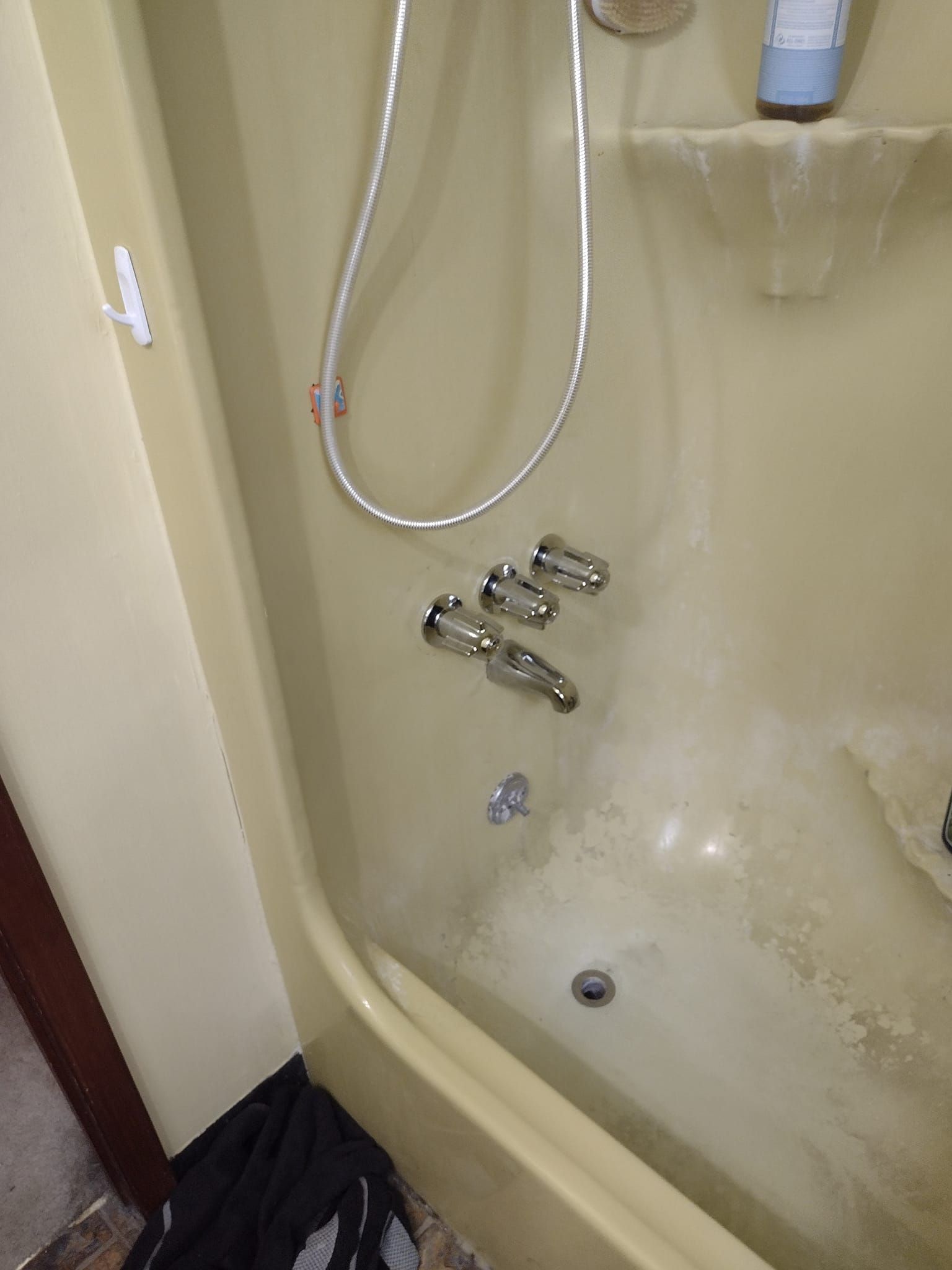 A bathtub with a shower head and faucets in a bathroom.
