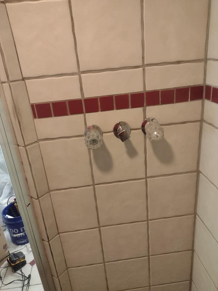A bathroom with white tiles and red stripes on the walls.