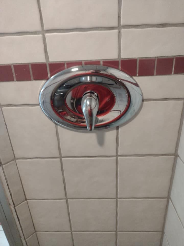 A shower head is hanging from the ceiling in a bathroom.