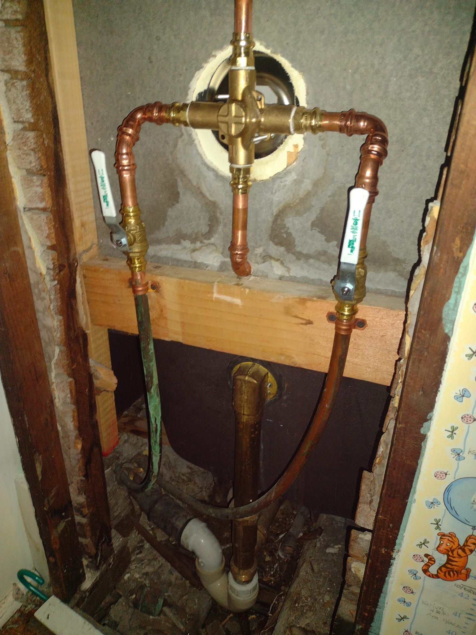 A copper pipe is connected to a faucet in a bathroom.