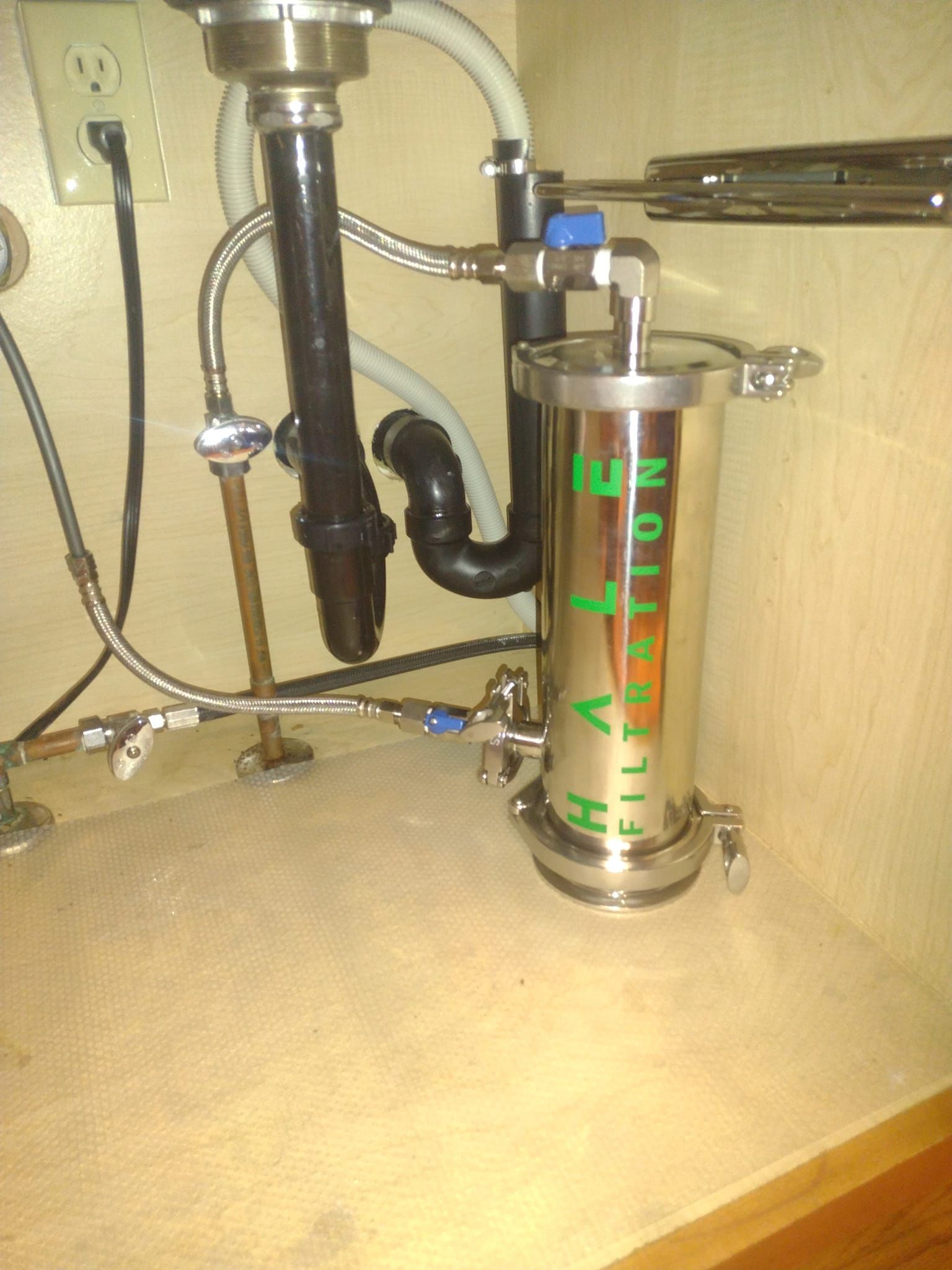 A stainless steel water filter is under a sink