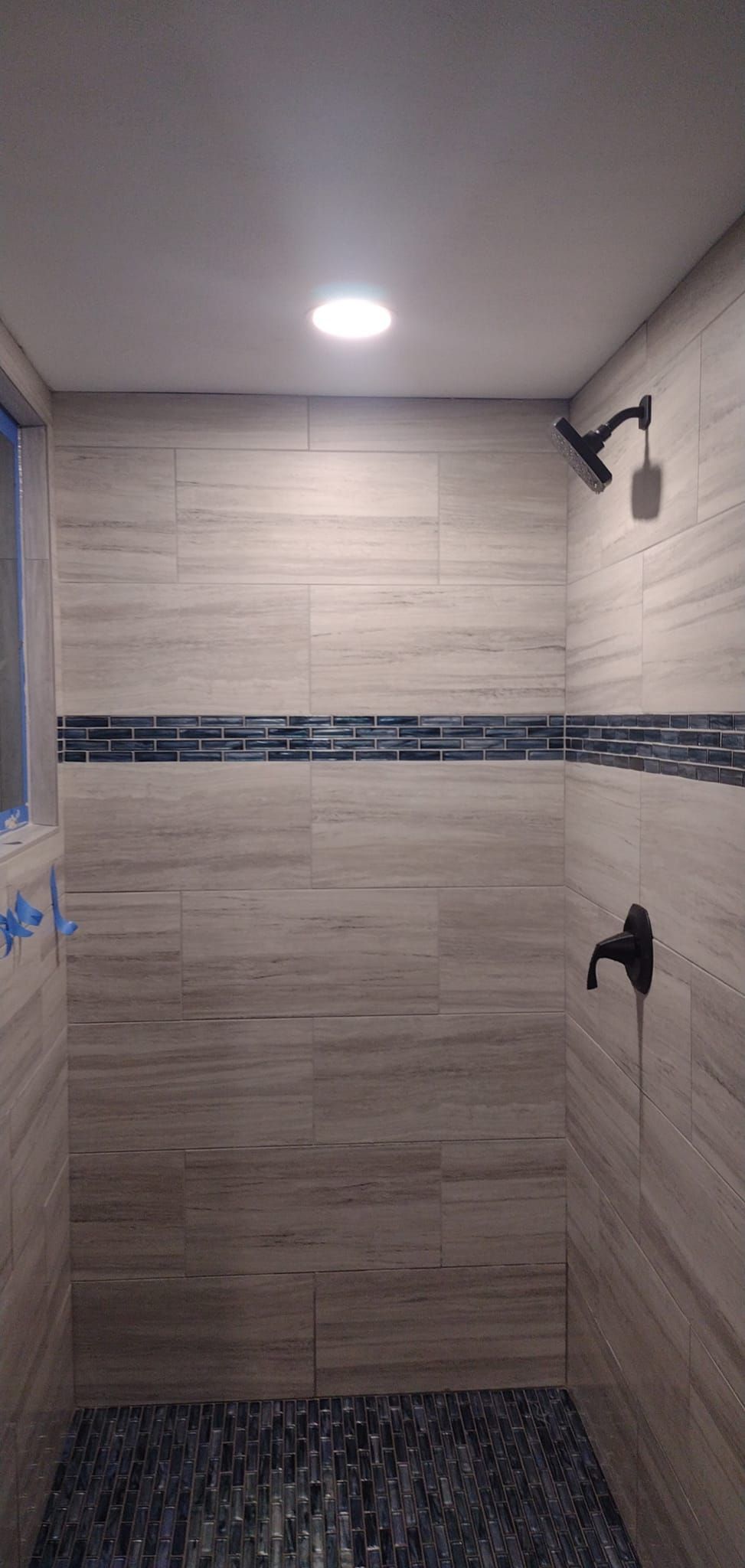 A bathroom with a shower and a window.