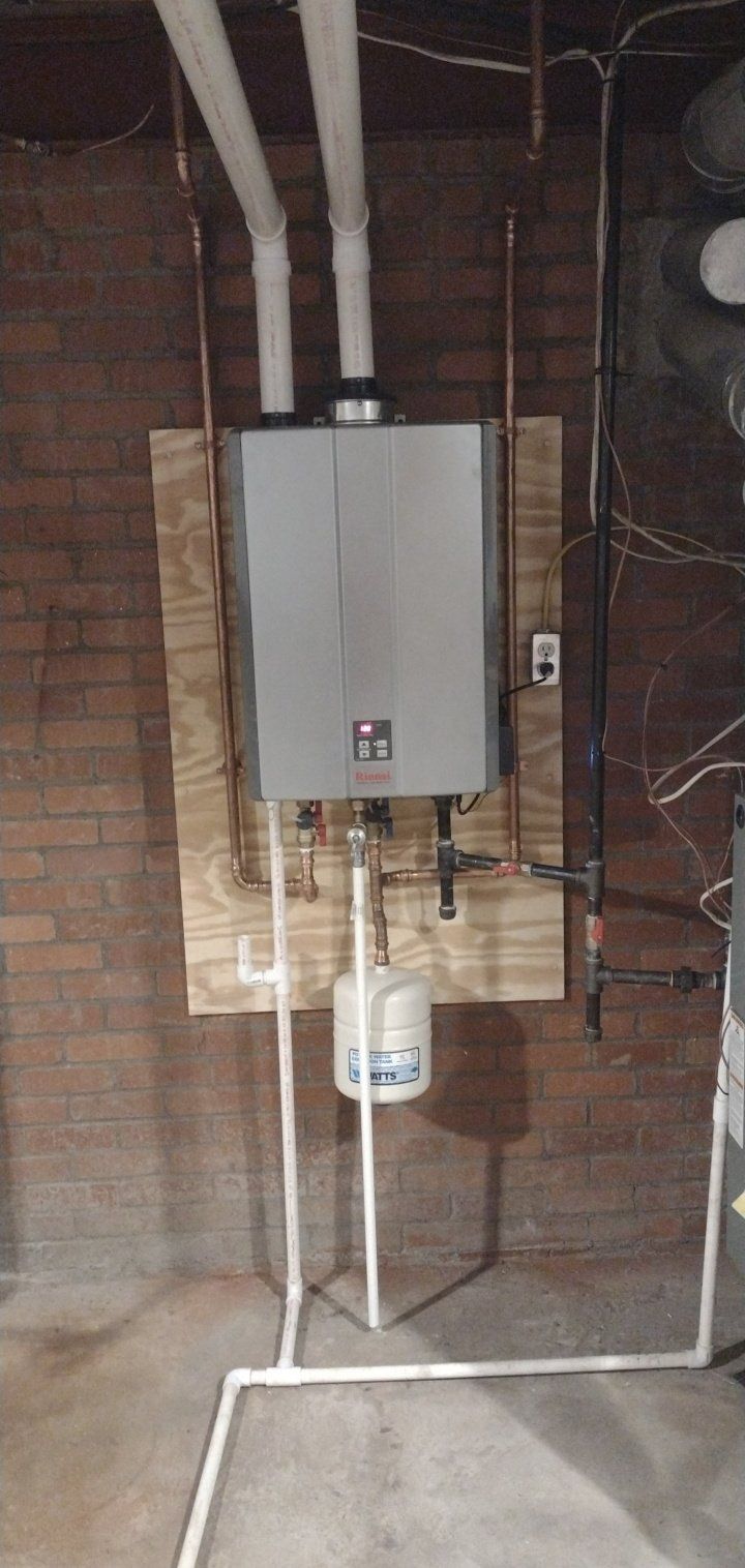 A water heater is hanging on a wall in a basement.