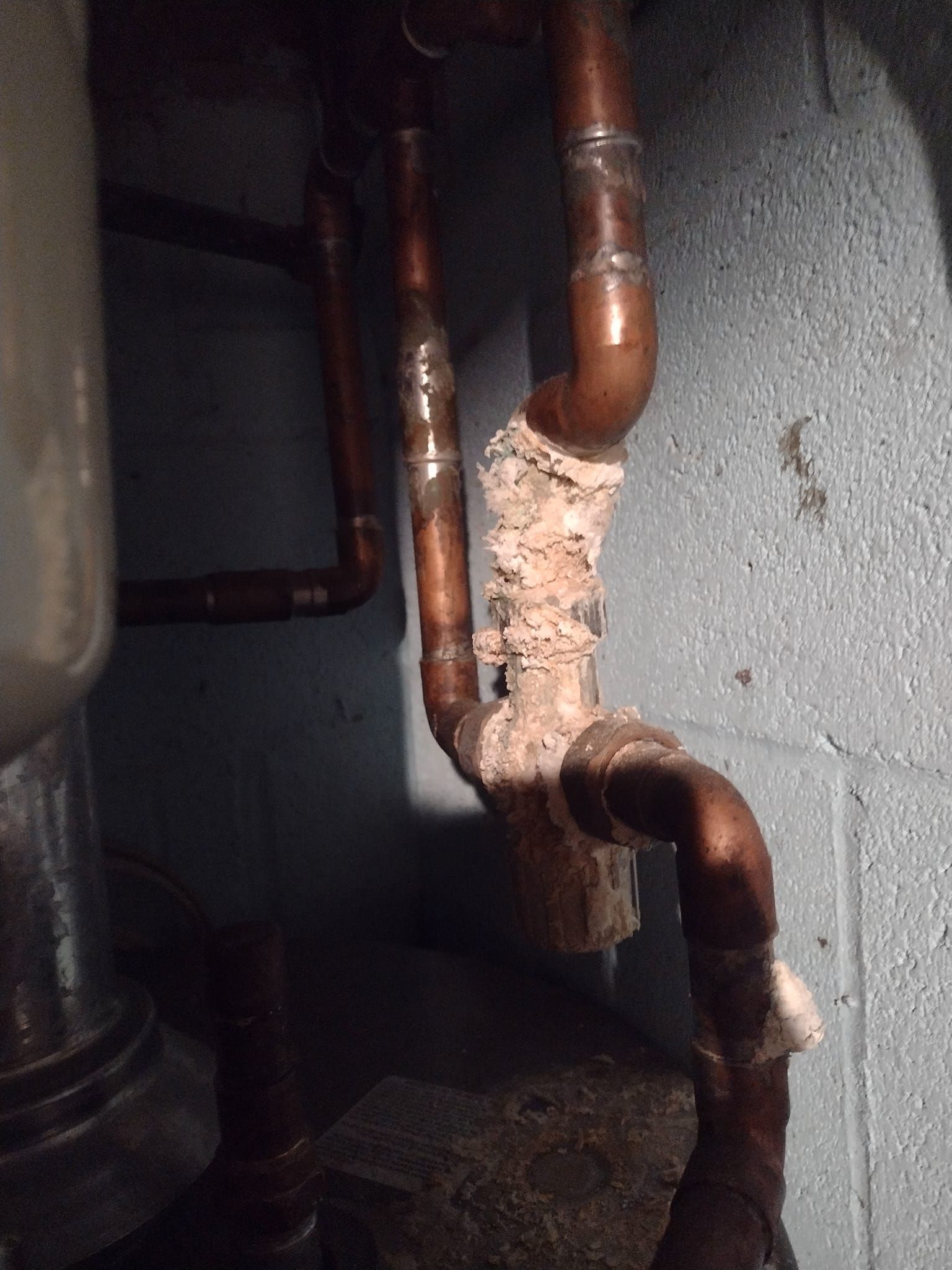 A close up of a copper pipe in a basement