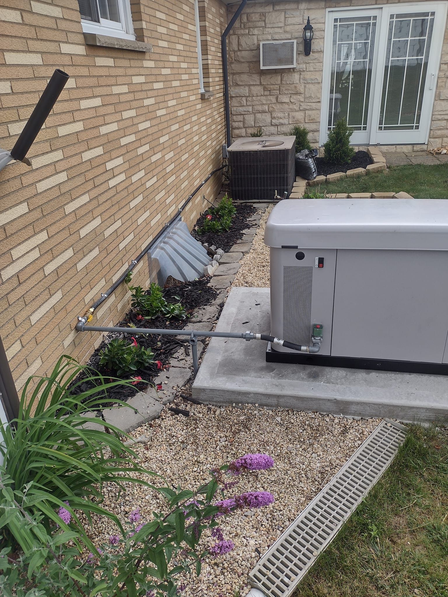 A hot tub is sitting in the backyard of a brick house.