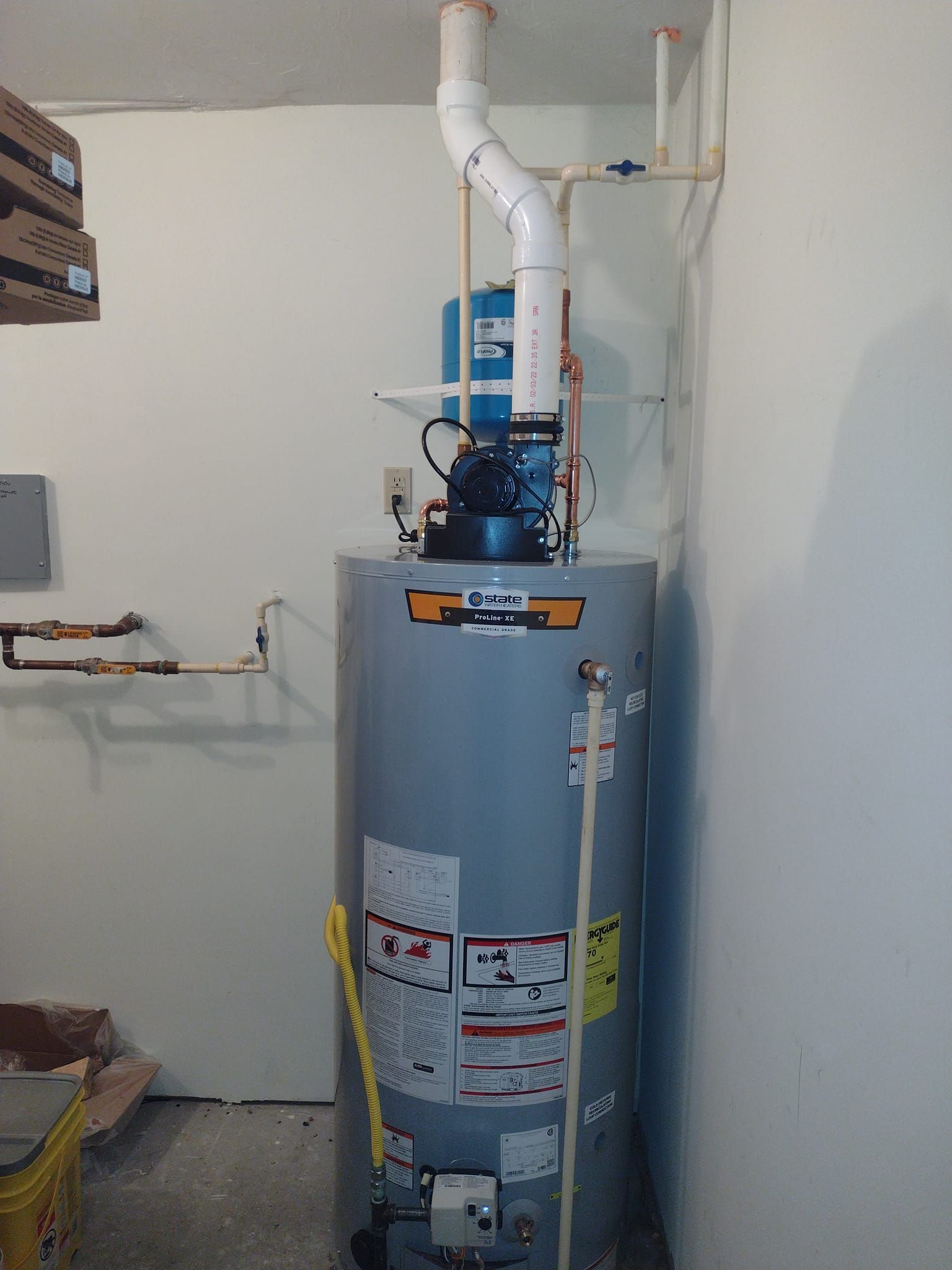 A water heater is sitting in a room next to a wall.