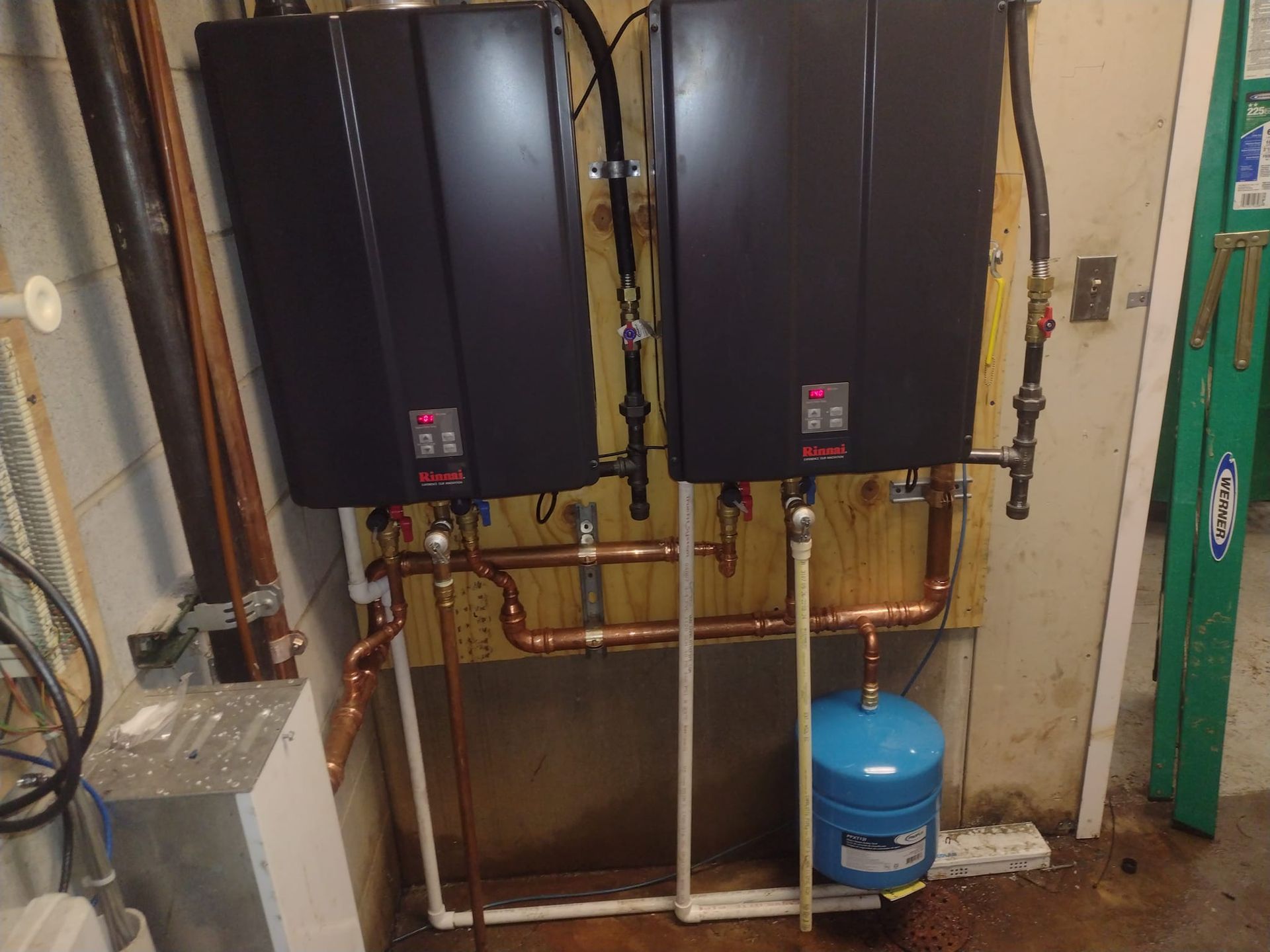 Two water heaters are sitting next to each other on a wall.