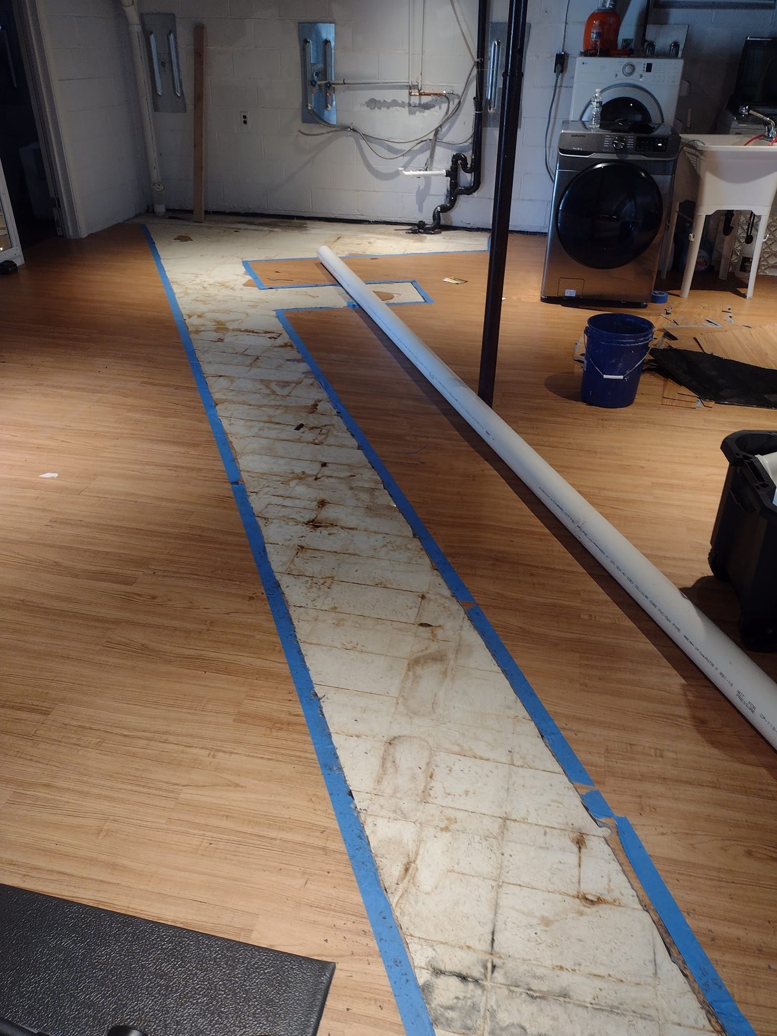 A dirty basement with a washer and dryer in it