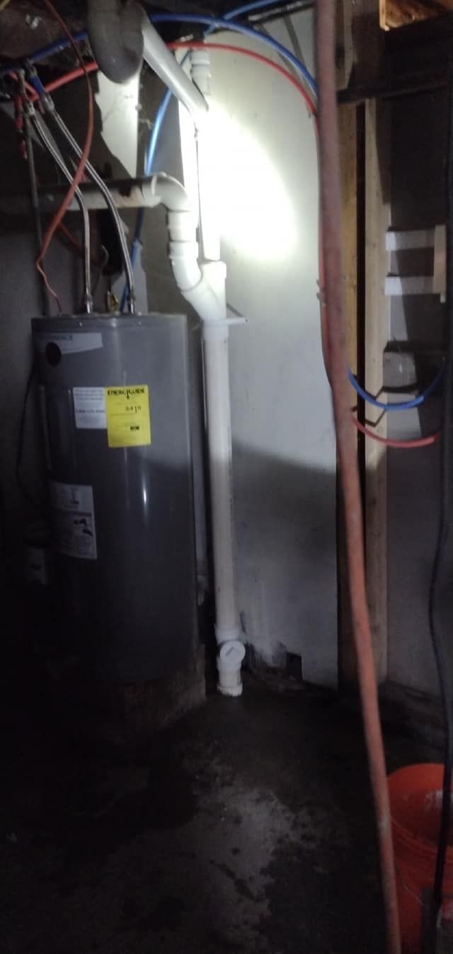 There is a water heater in the basement of a house.