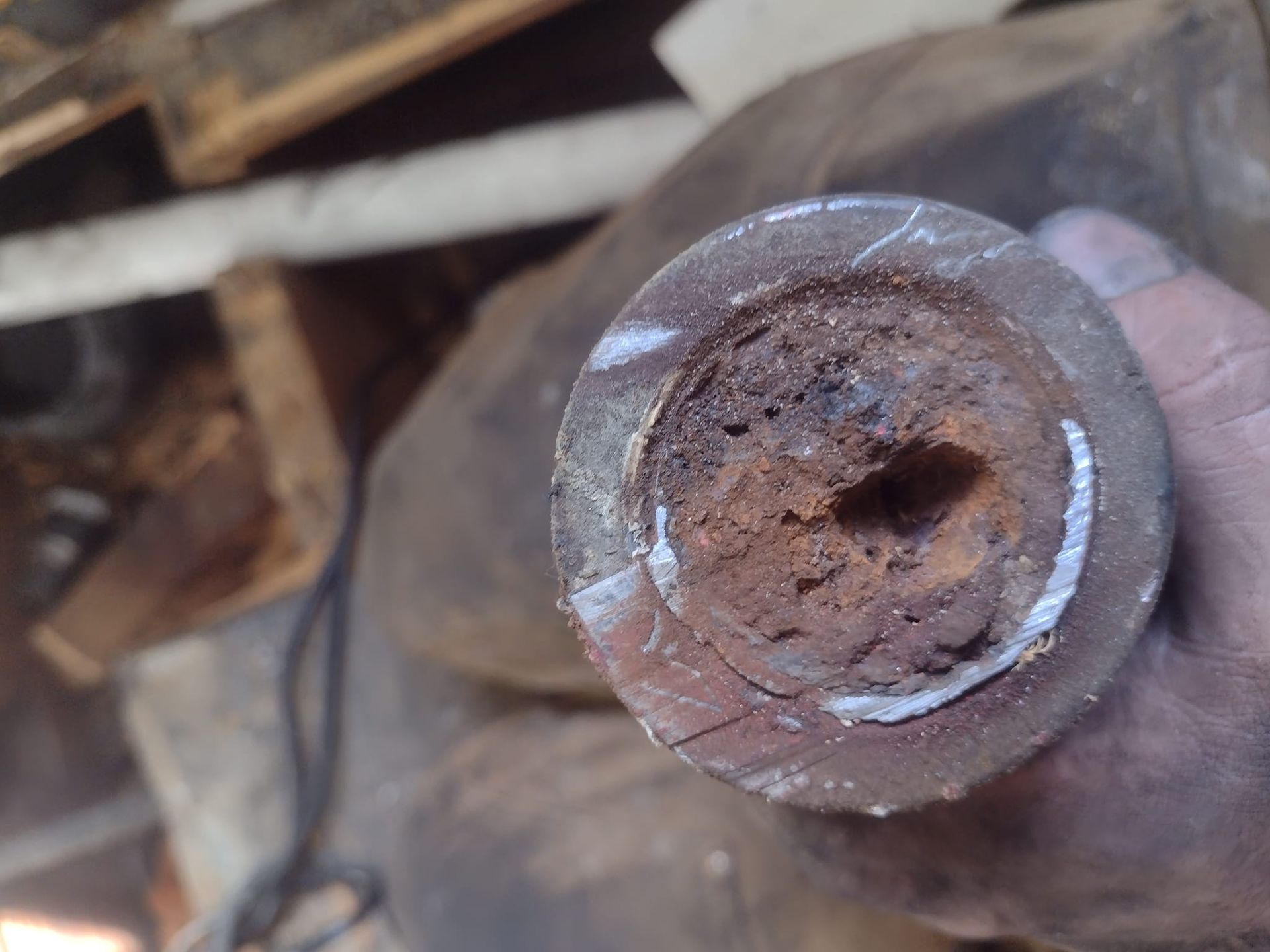A person is holding a piece of rusty metal in their hand.
