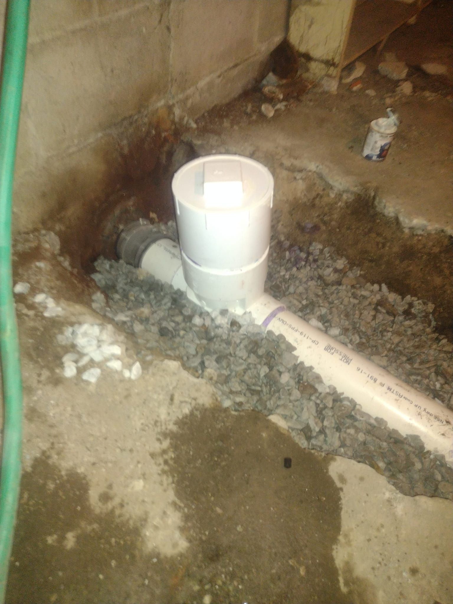 A drain pipe is being installed in a hole in the ground.