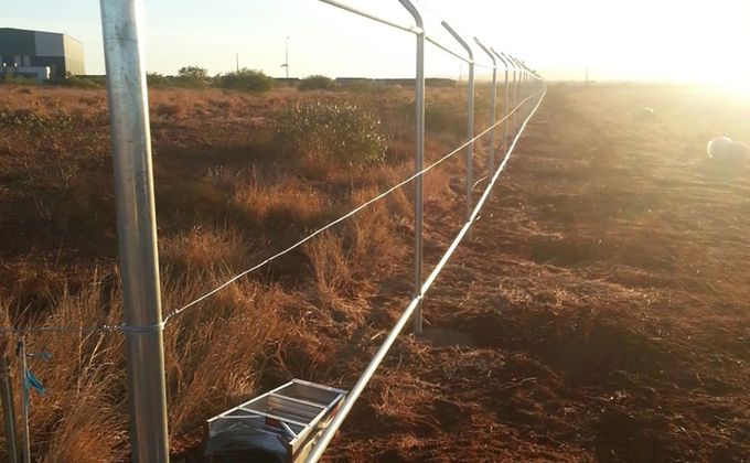 A fence is being built in the middle of a field.