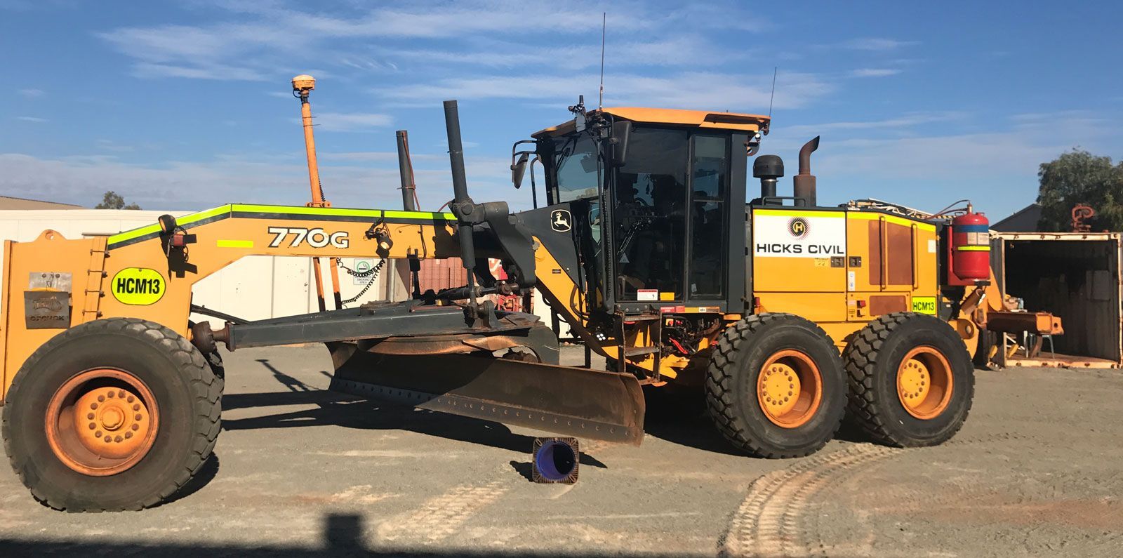 A yellow tractor is parked in a parking lot.