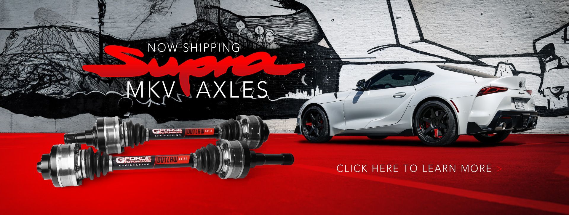 A white sports car is sitting on a red surface next to a pair of axles.