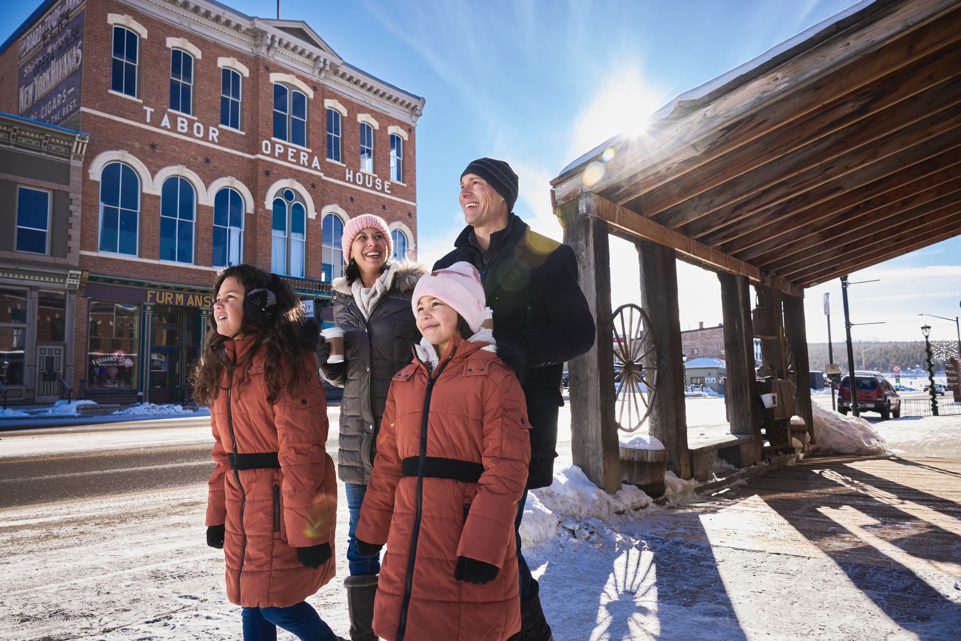 Family walking along Harrison Avenue in Leadville, Colorado in the winter, Tabor Opera House in the background