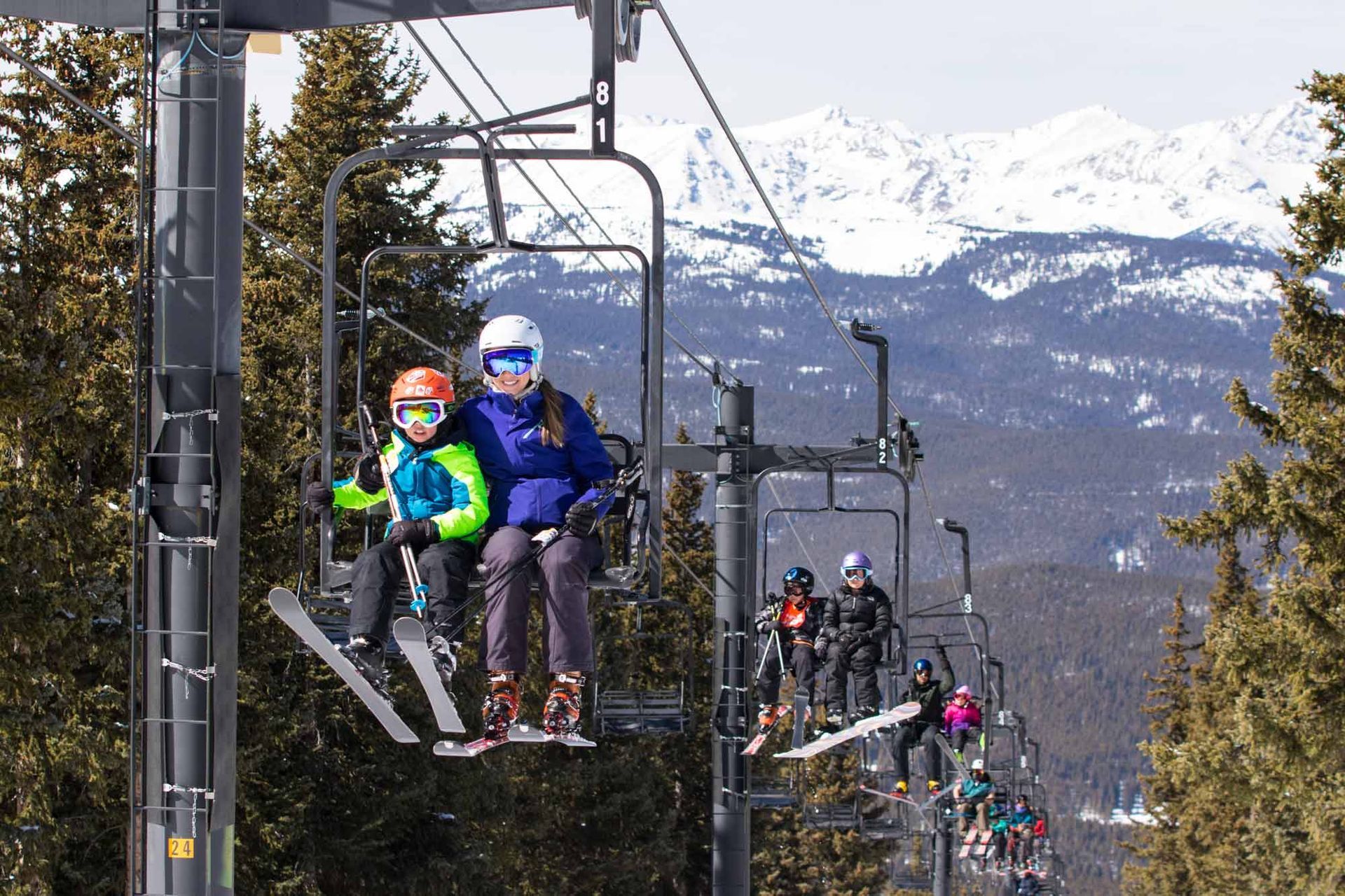 skiing families riding a 2 person chair lift at Ski Cooper