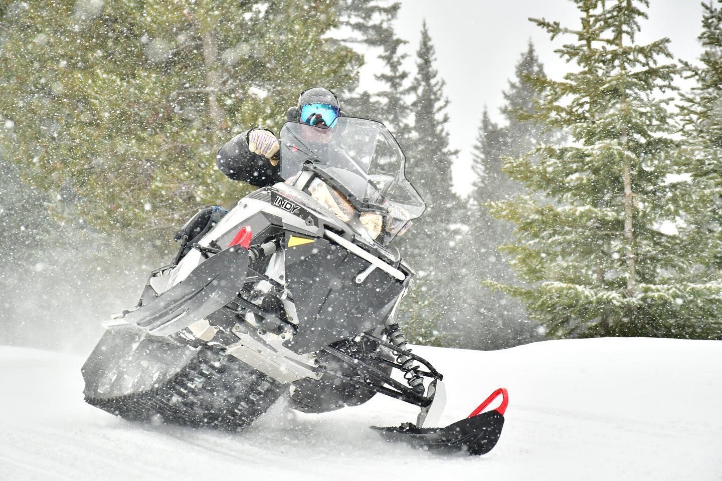 A person is riding a snowmobile in the snow.