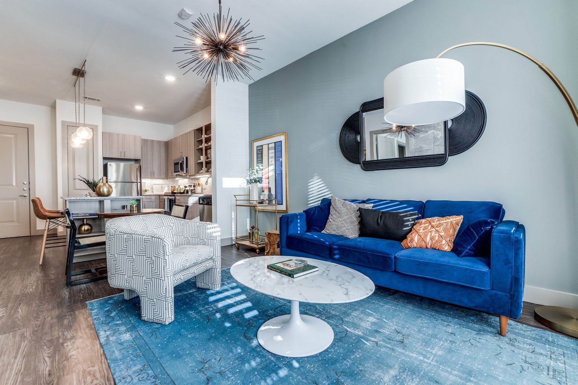 A living room with a blue couch and a white coffee table.
