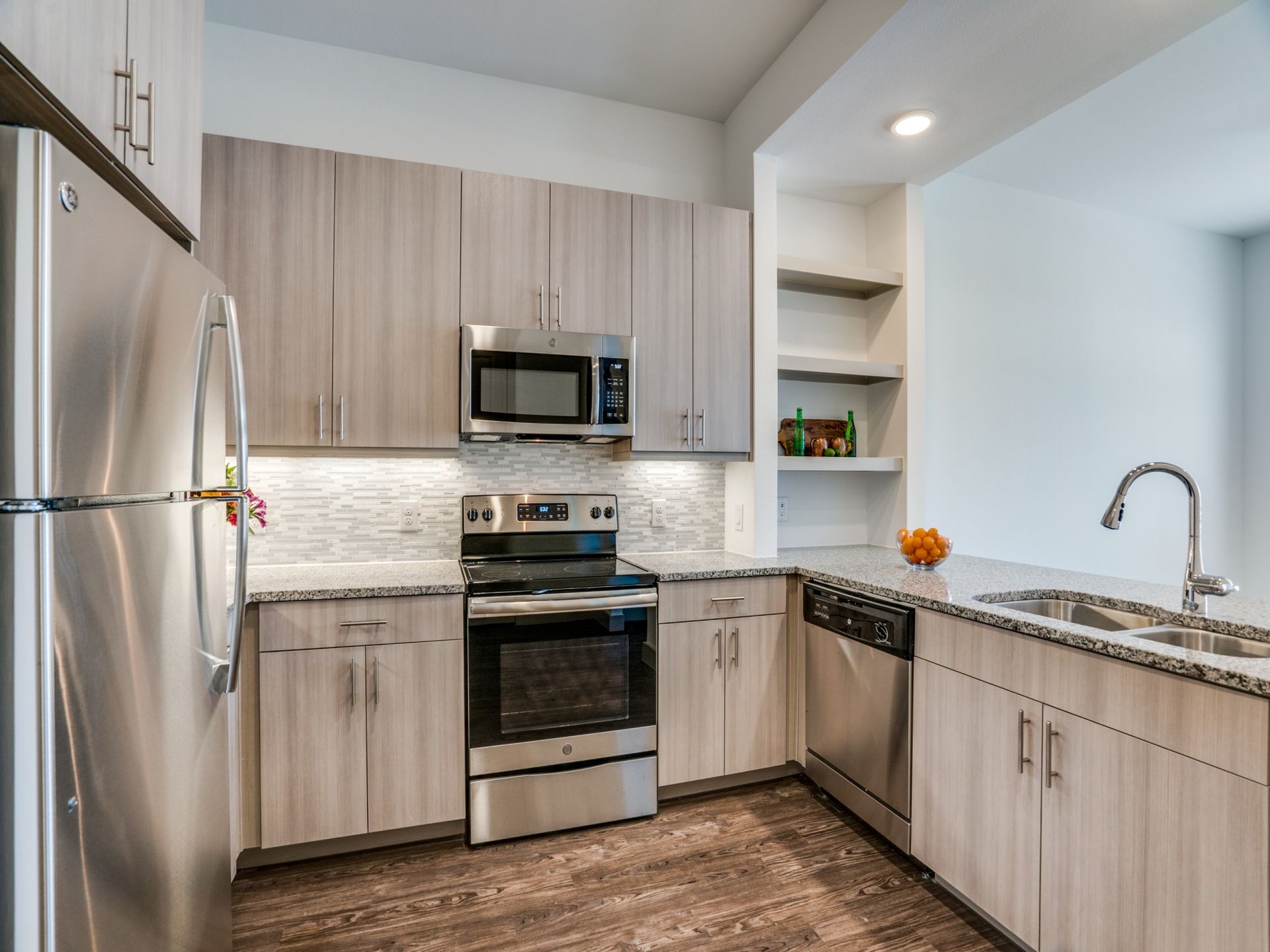A kitchen with stainless steel appliances and wooden cabinets