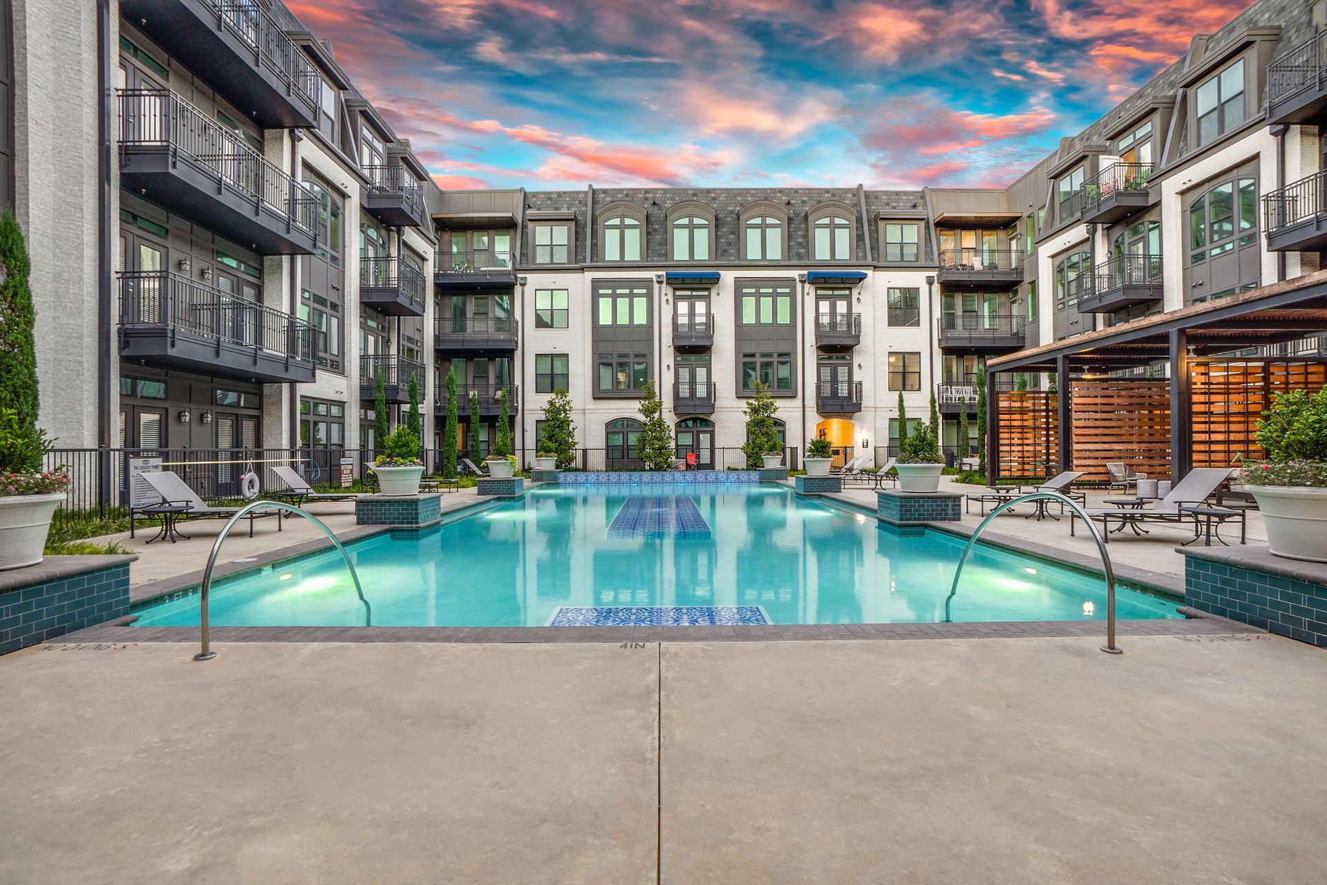 A large swimming pool in the middle of a large apartment building.