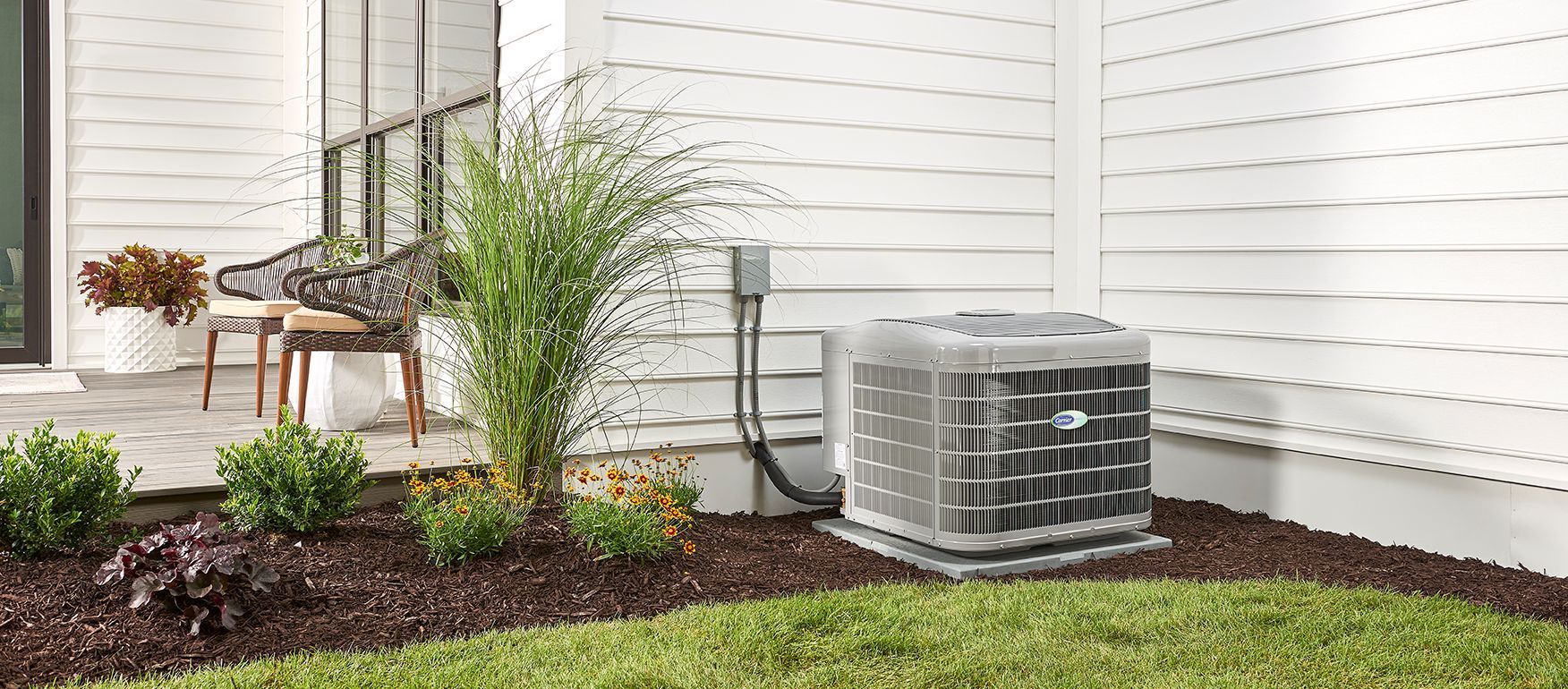 An air conditioner is sitting in the backyard of a house.