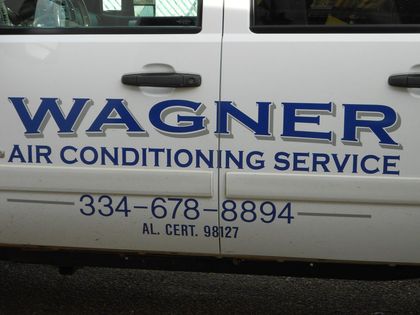 A man is working on an air conditioner outside of a house.