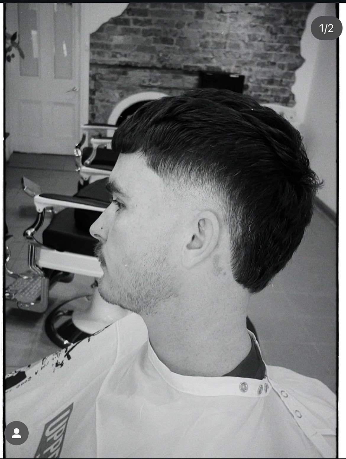 Man with a faded haircut in a barber shop, wearing a white cape. — Eagle Tamer Barbershop in Stratford, QLD