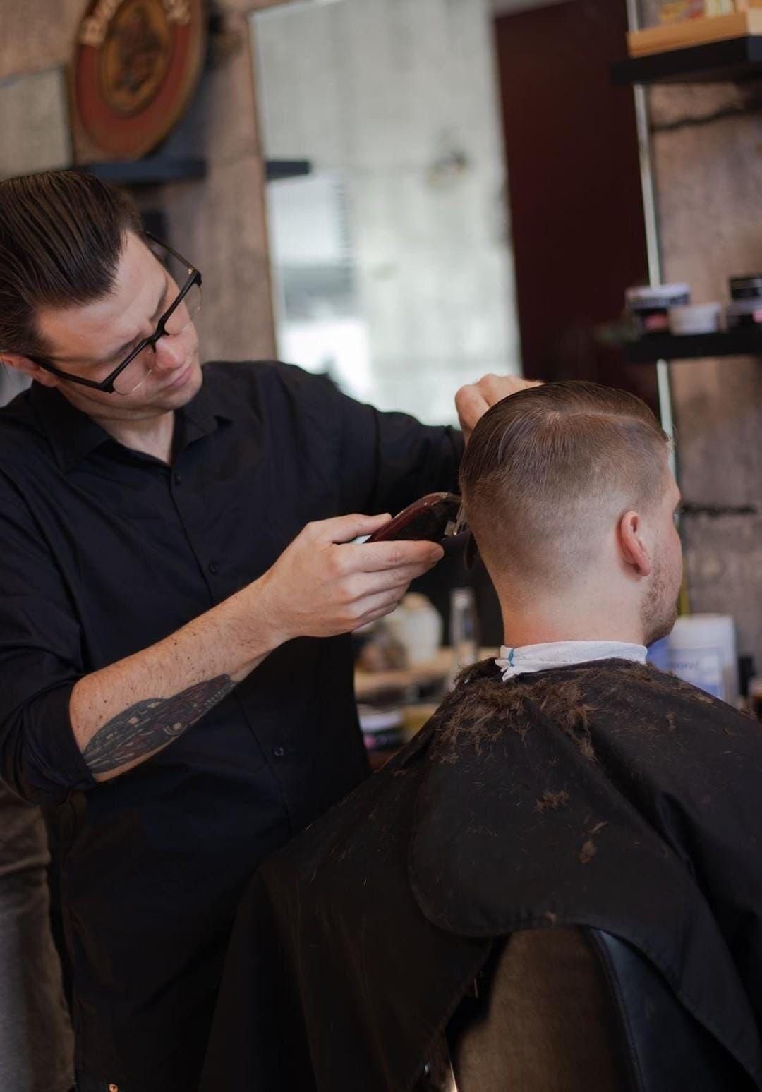 Barber Cutting a Man's Hair With Clippers in a Shop — Eagle Tamer Barbershop in Stratford, QLD