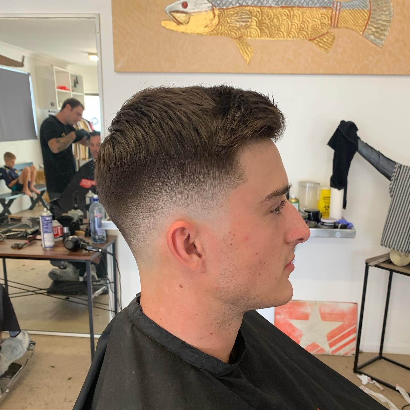 Man getting a haircut, fading from skin to dark brown, in a barbershop. — Eagle Tamer Barbershop in Stratford, QLD