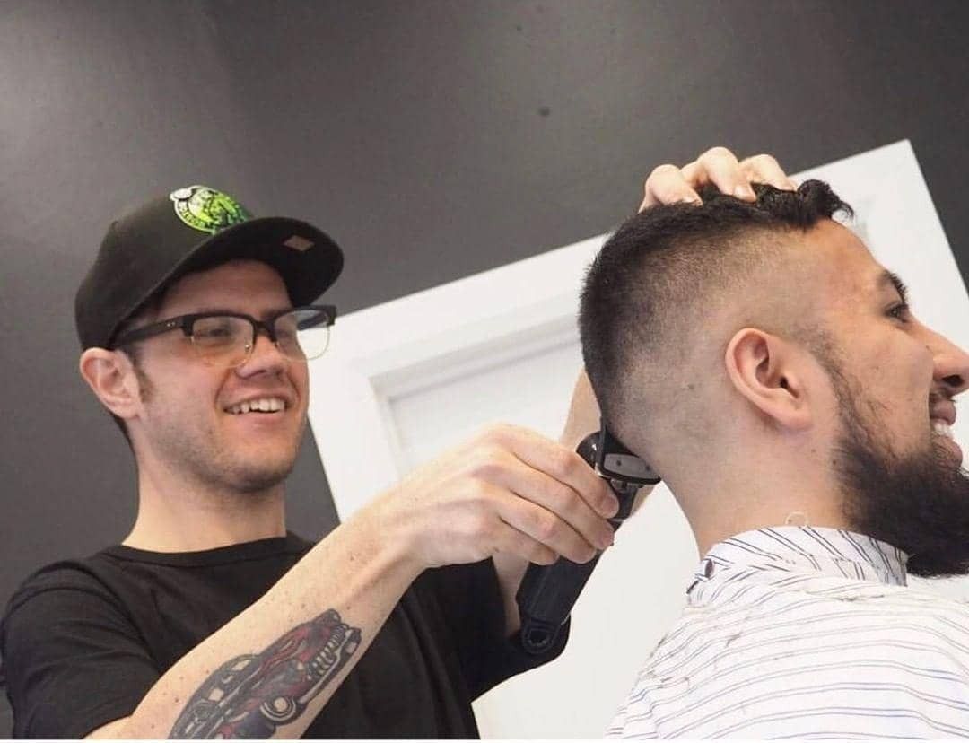 Barber Cutting a Man's Hair in a Salon Using a Comb and Scissors — Eagle Tamer Barbershop in Stratford, QLD