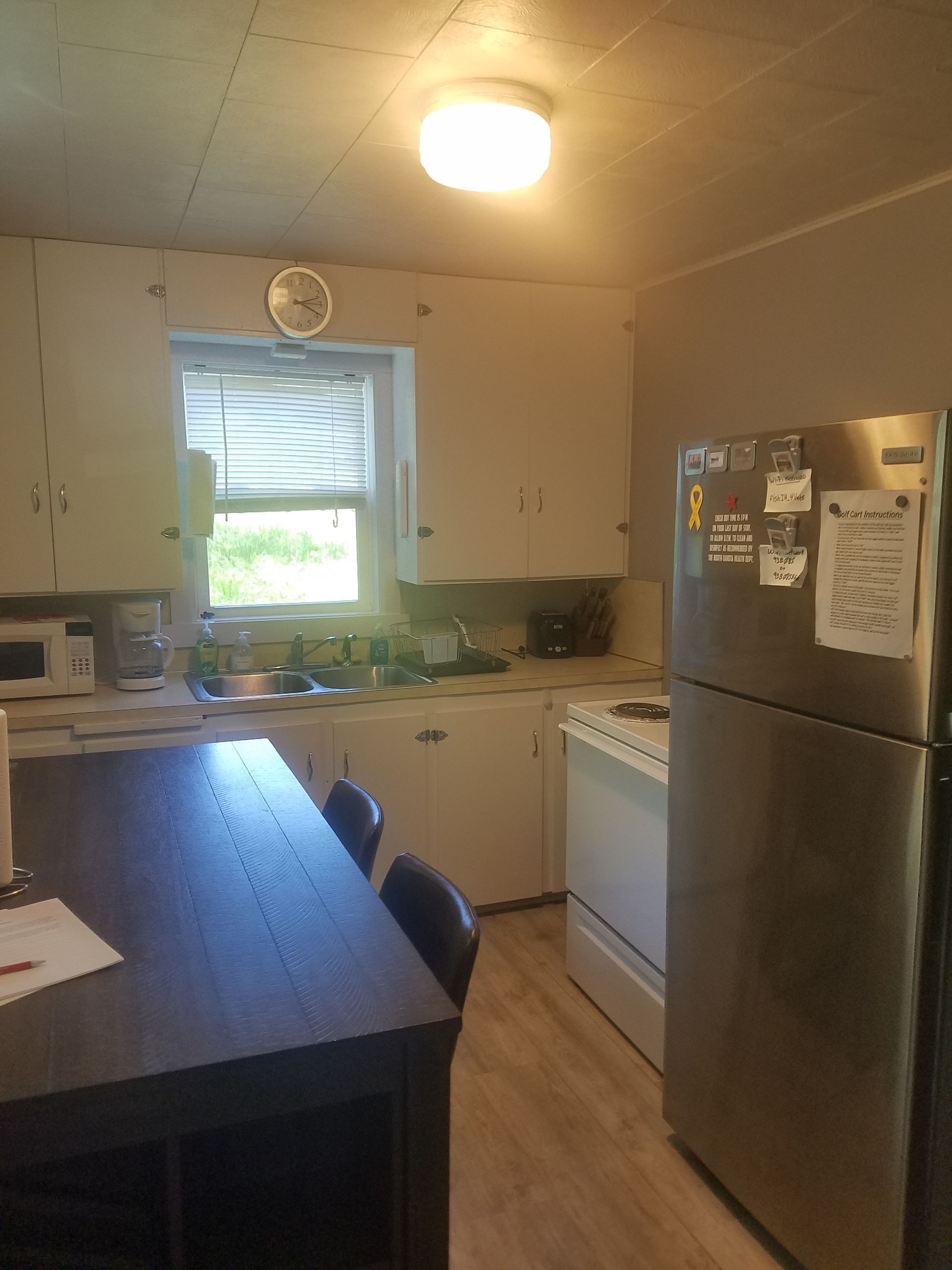 A kitchen with white cabinets and a stainless steel refrigerator
