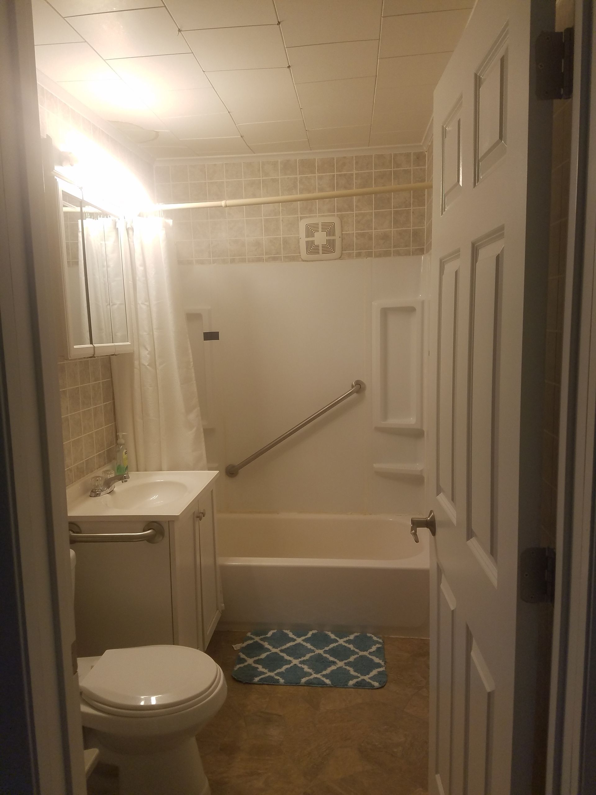 A bathroom with a toilet , sink , and bathtub.