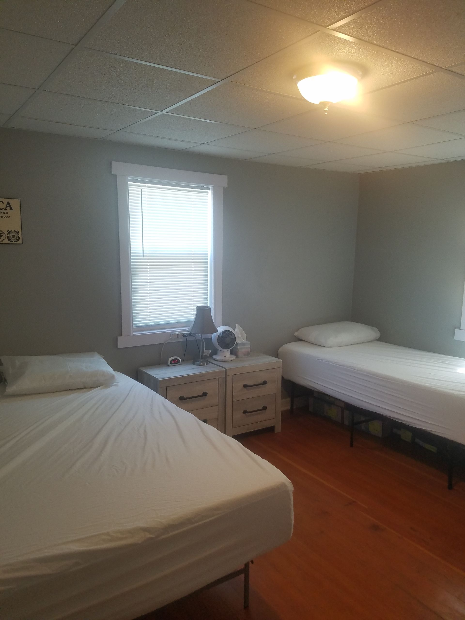 A bedroom with two beds and a window.