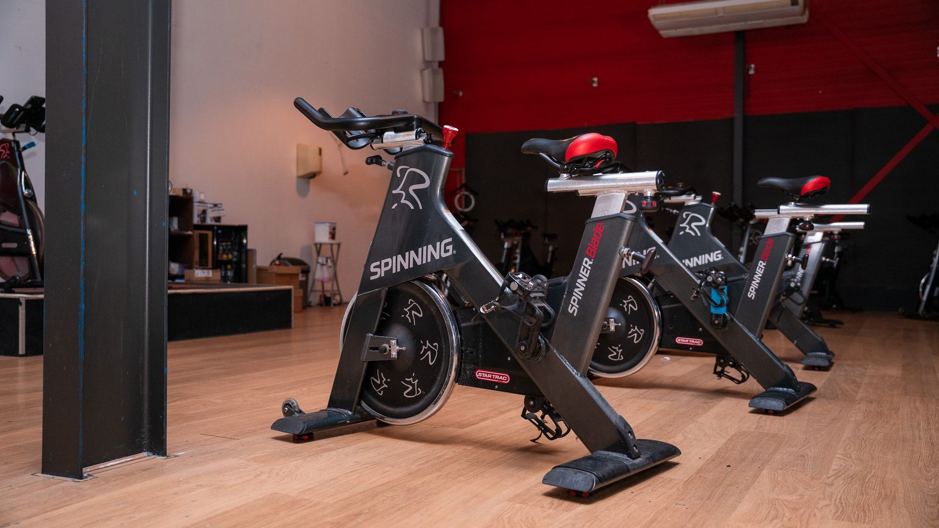 Een rij hometrainers staat opgesteld in een sportschool.