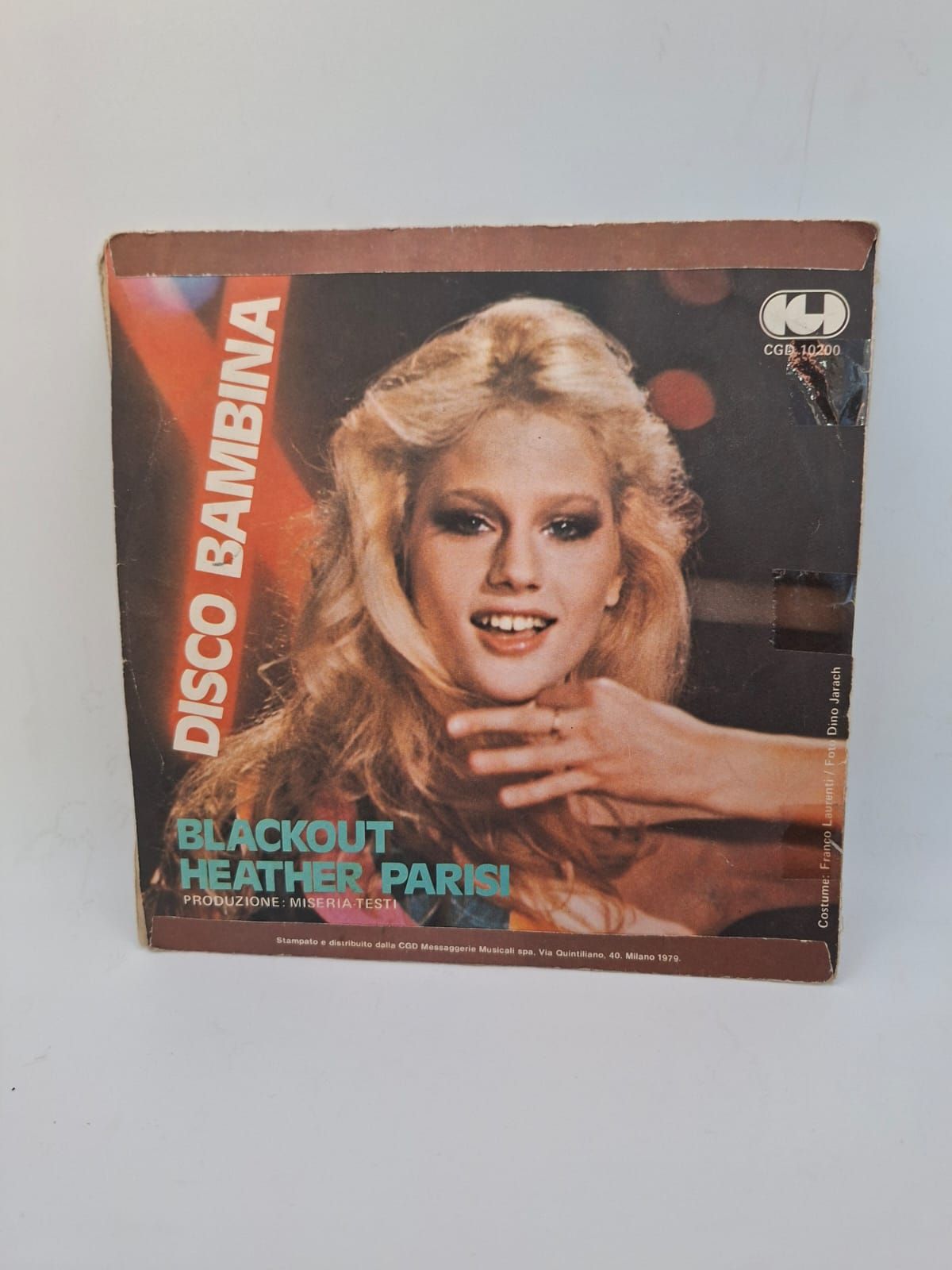 Copertina di un disco in vinile raffigurante una persona bionda in posa con le mani vicino al viso, intitolato 