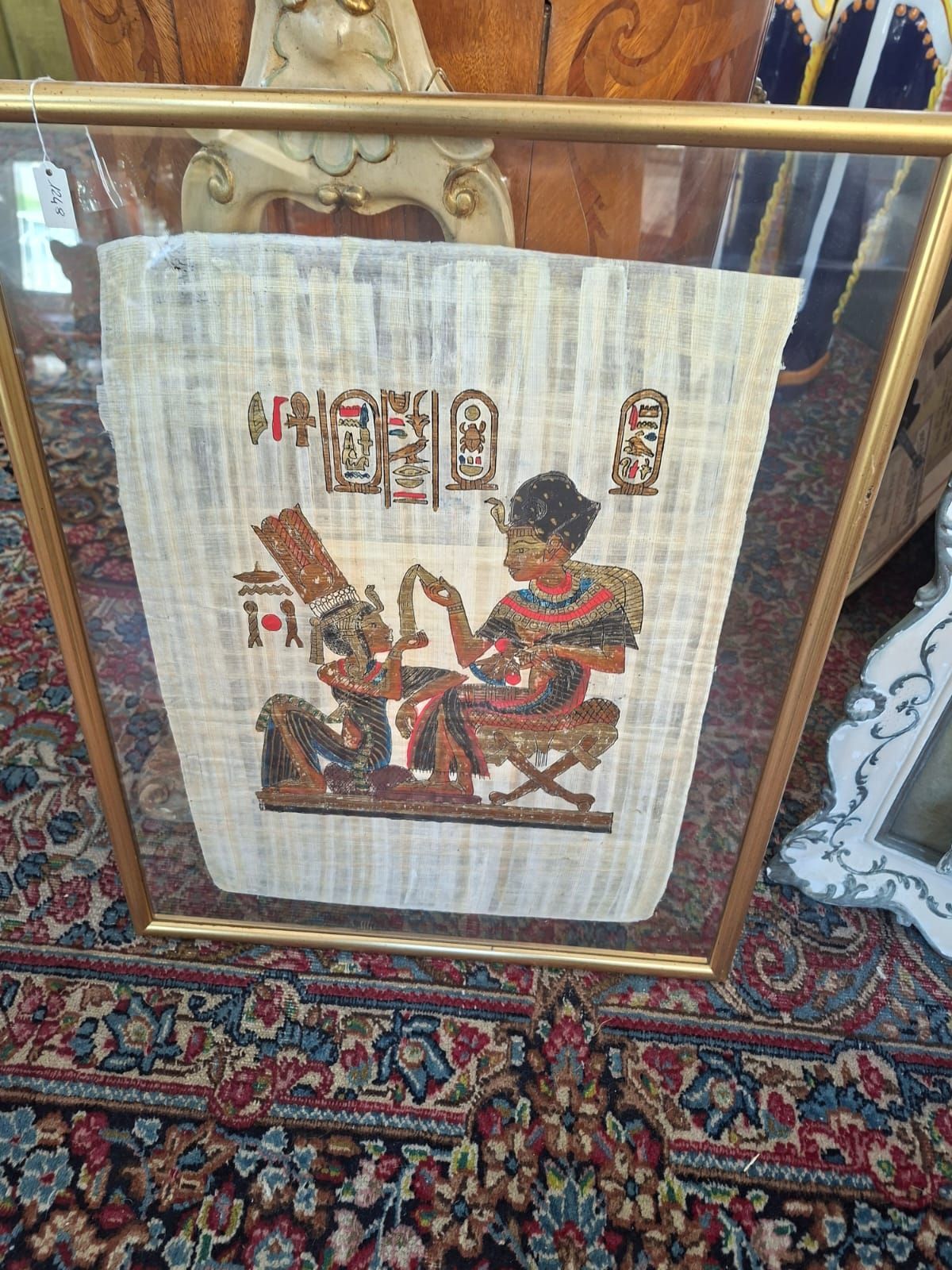 Dipinto su papiro incorniciato raffigurante due figure dell'antico Egitto, una seduta e una in piedi, con geroglifici sopra di esse.