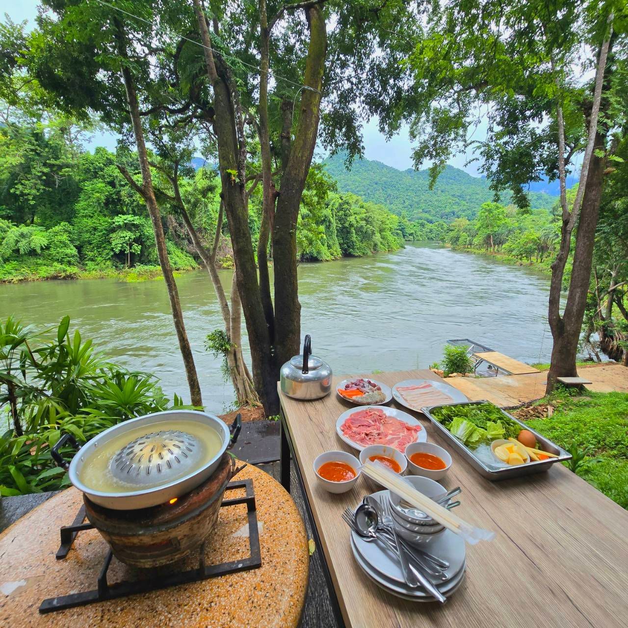 A table with food on it and a river in the background