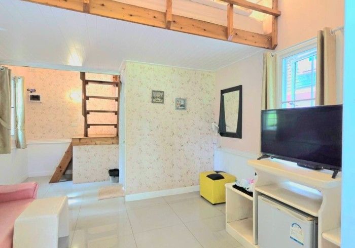 A living room with a flat screen tv and a staircase leading to the second floor.