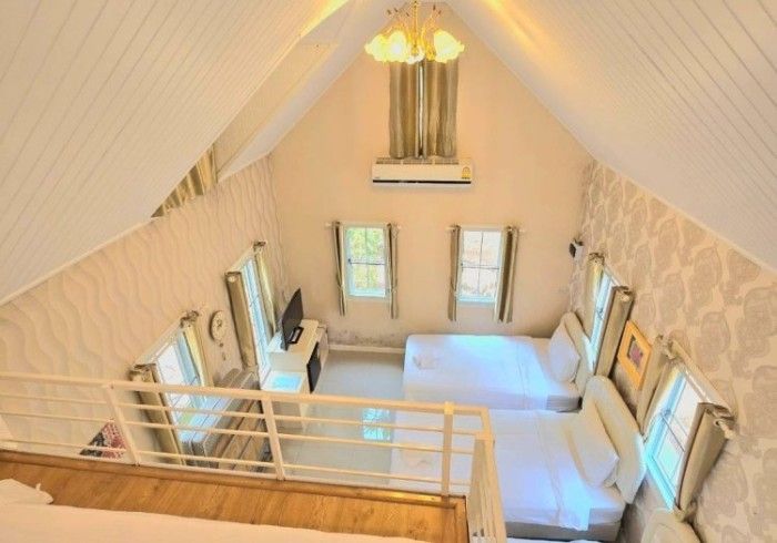 An aerial view of a bedroom with two beds and a balcony.